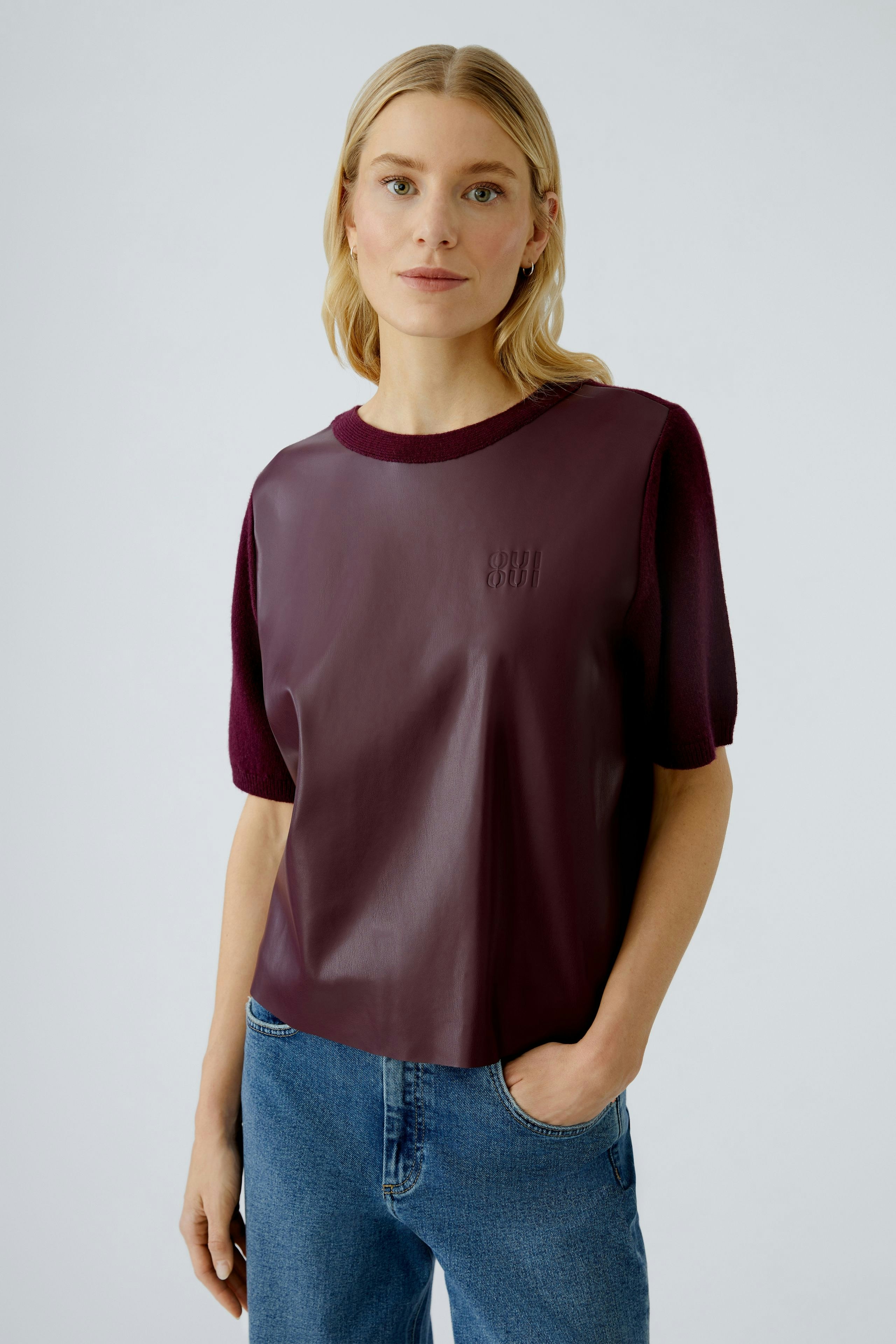 Damen-Pullover: Frau in bordeauxfarbenem, lässigem Pullover mit kurzen Ärmeln und modernem Design.