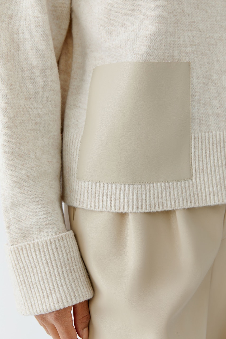 Beiger Damen-Pullover mit lässigem Schnitt und großem, beigem Einsatz an der Seite.