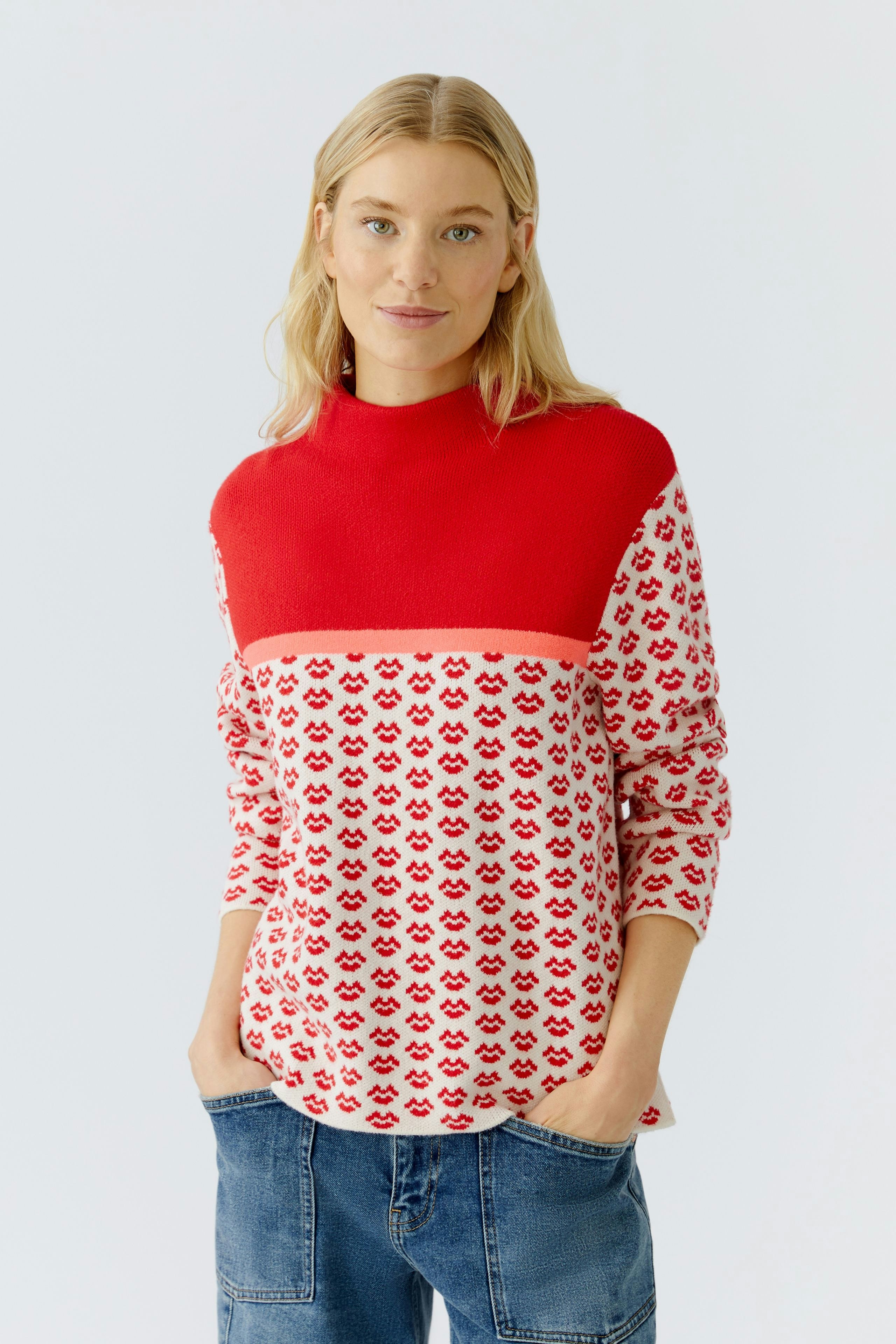 Casual women's pullover: Young woman in a red and patterned pullover with a relaxed fit.