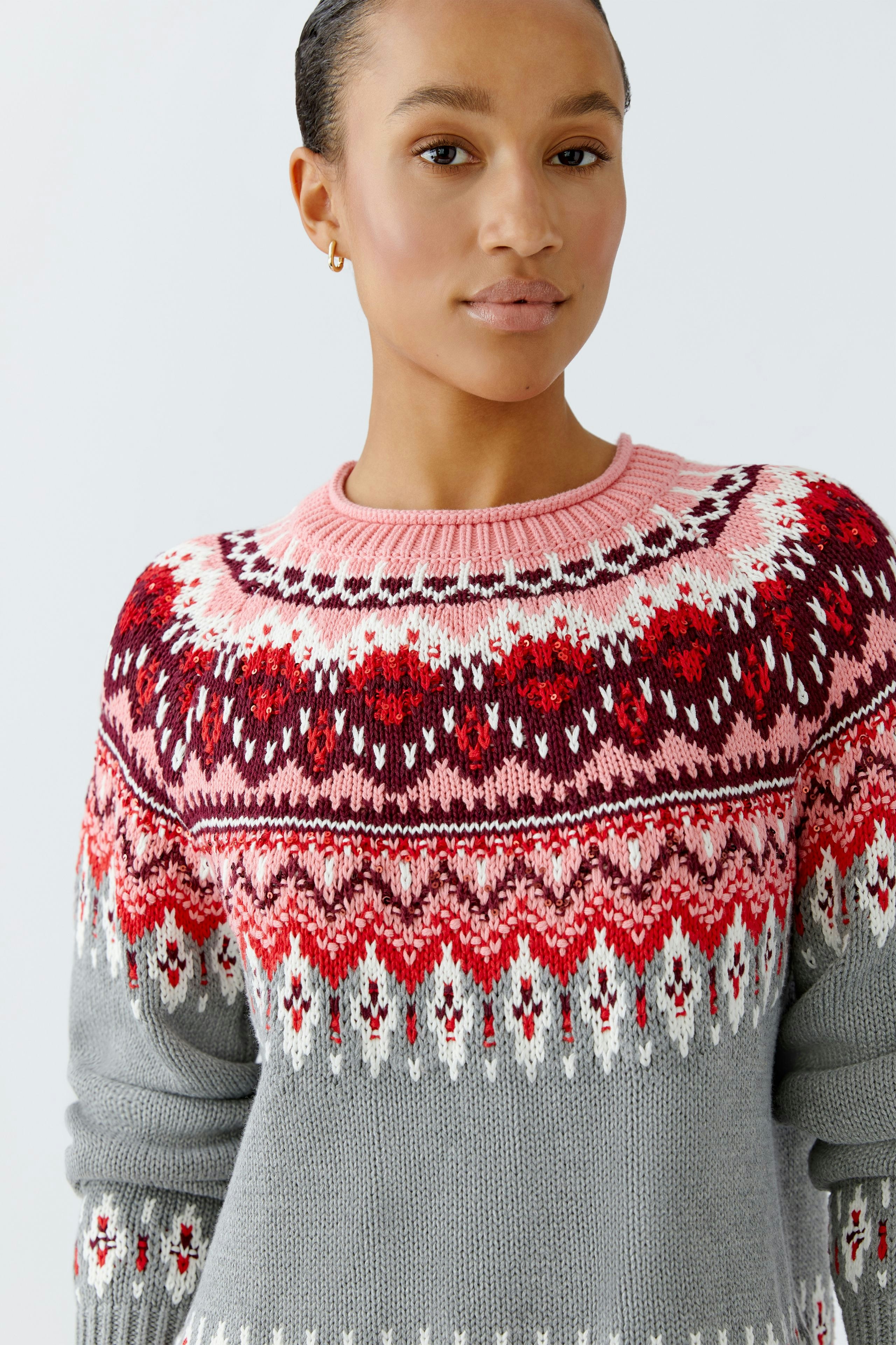 Colorful women's pullover: Young woman in a cozy, patterned pullover with a round neckline.