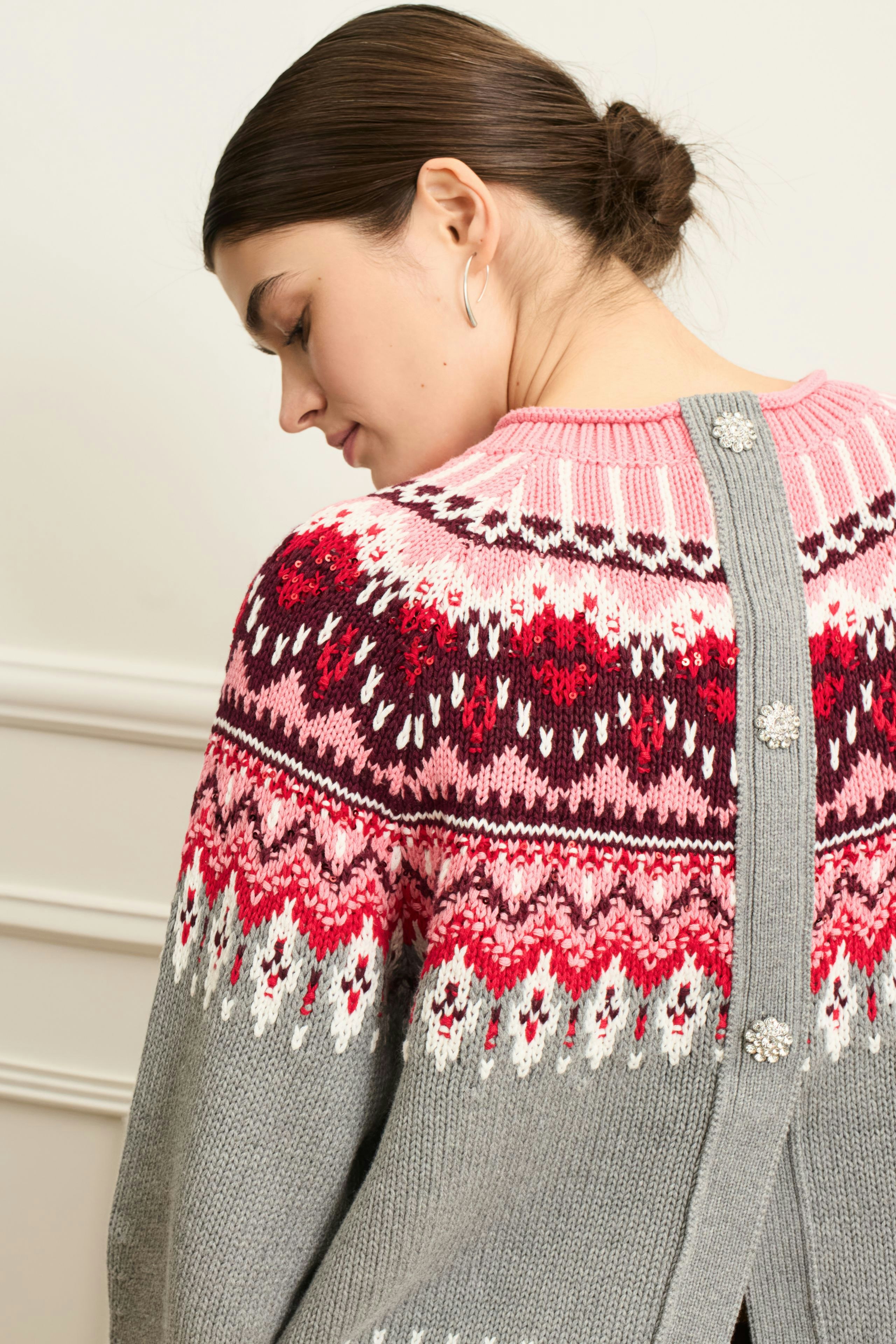 Cozy women's pullover: A woman in a colorful knit pullover with a unique back design.