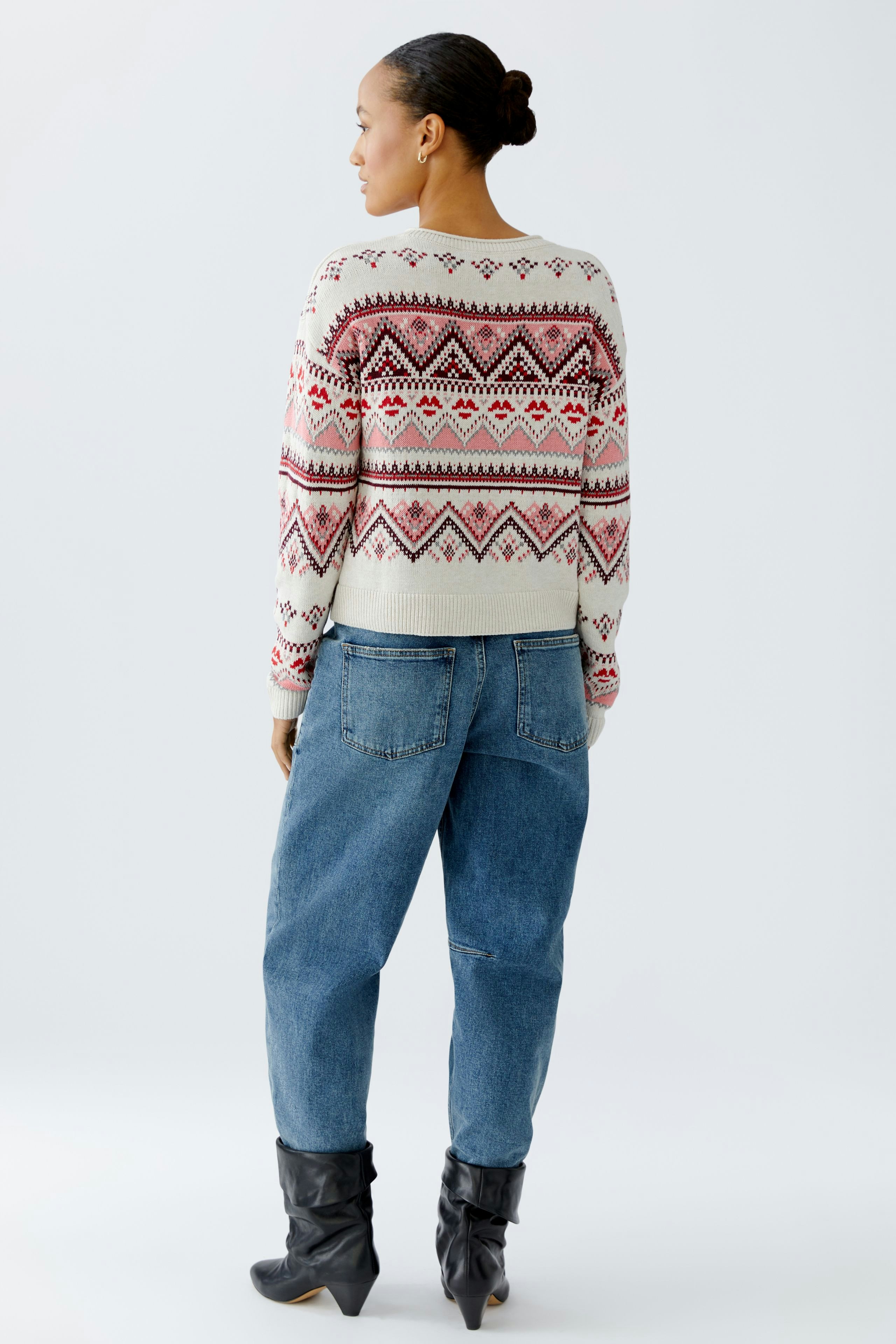 Casual women's pullover: A woman in a patterned pullover with a relaxed fit and stylish jeans.
