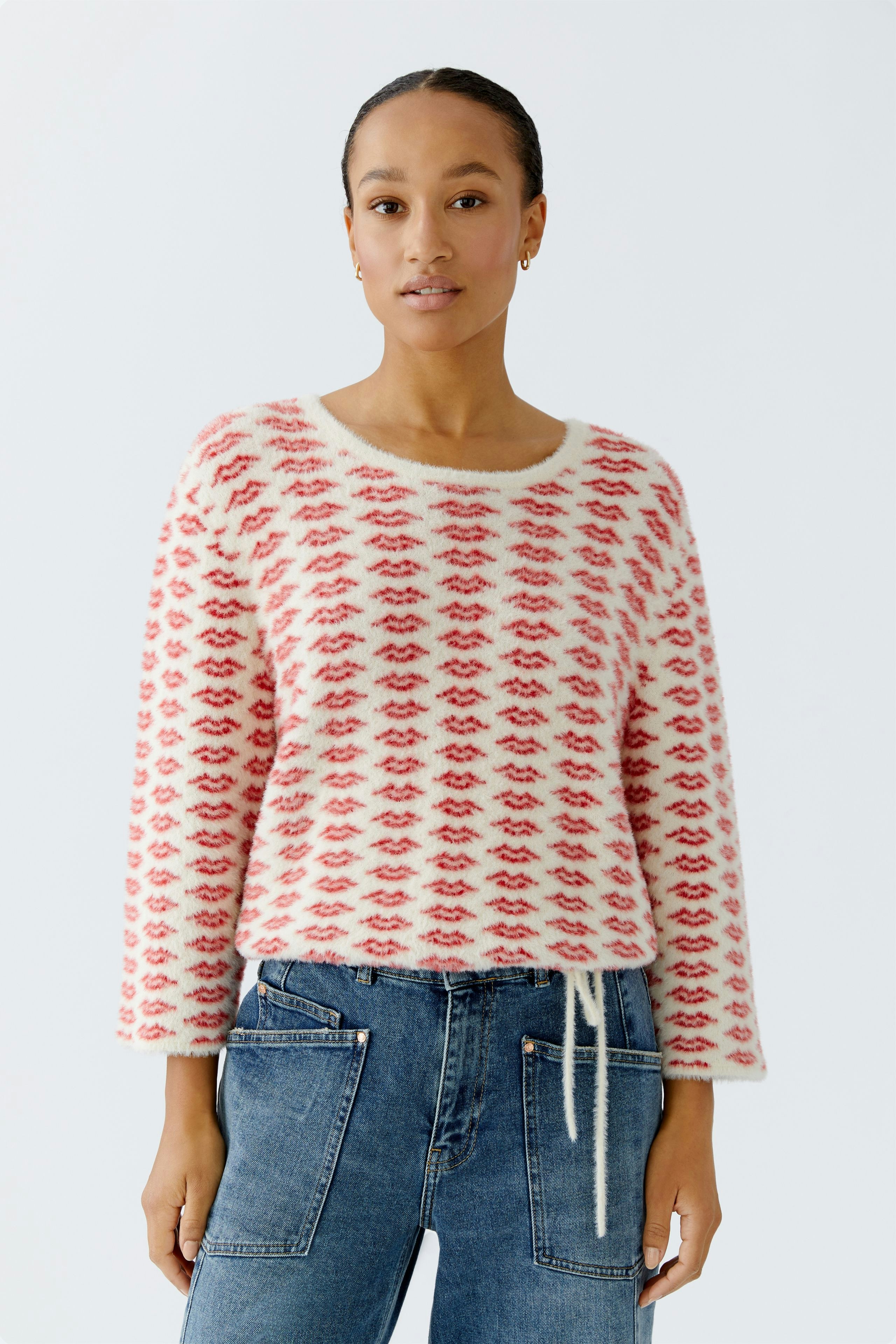 Casual women's pullover: Young woman in a cozy, patterned pullover with a relaxed fit and jeans.