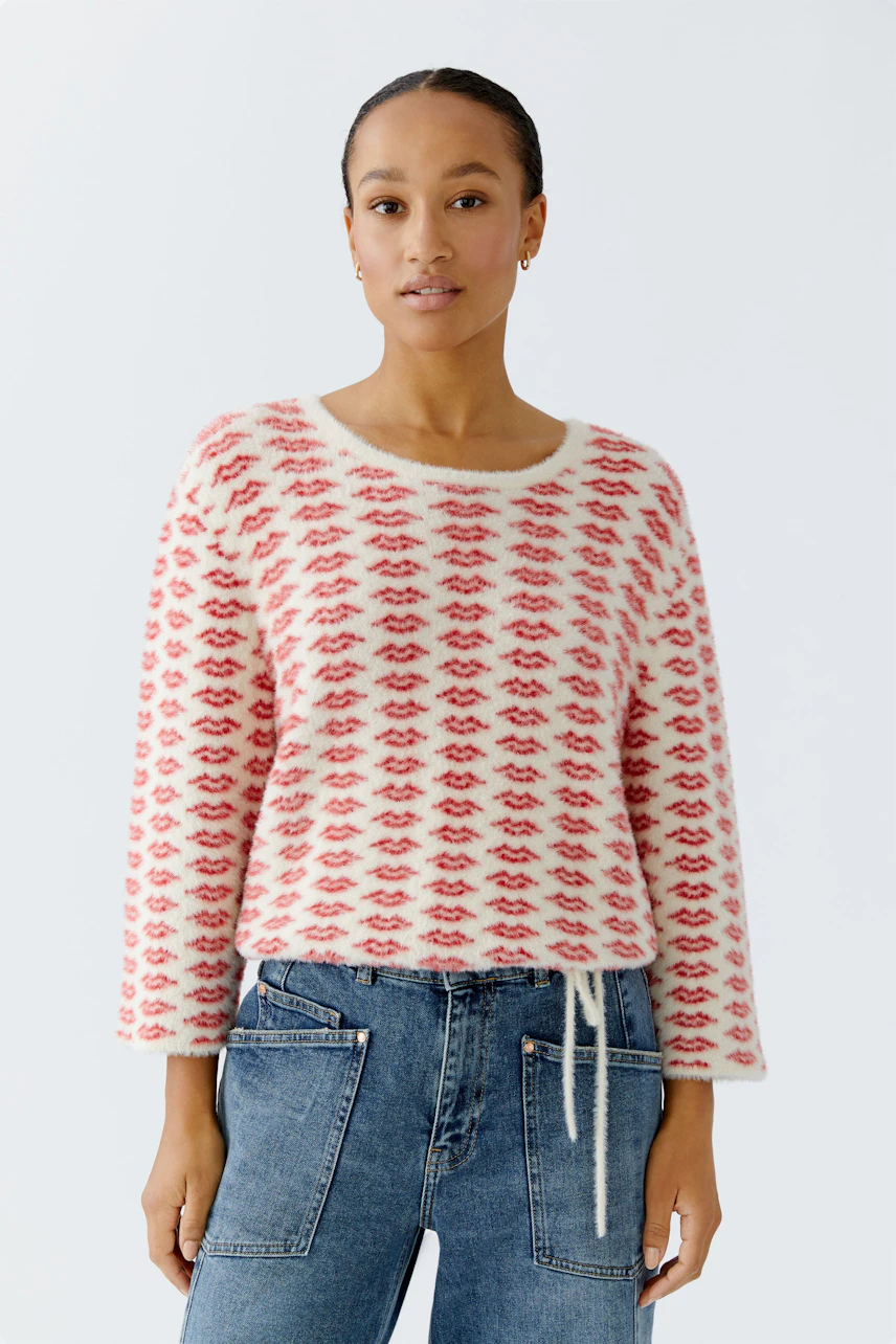 Casual women's pullover: Young woman in a cozy, patterned pullover with a relaxed fit and jeans.