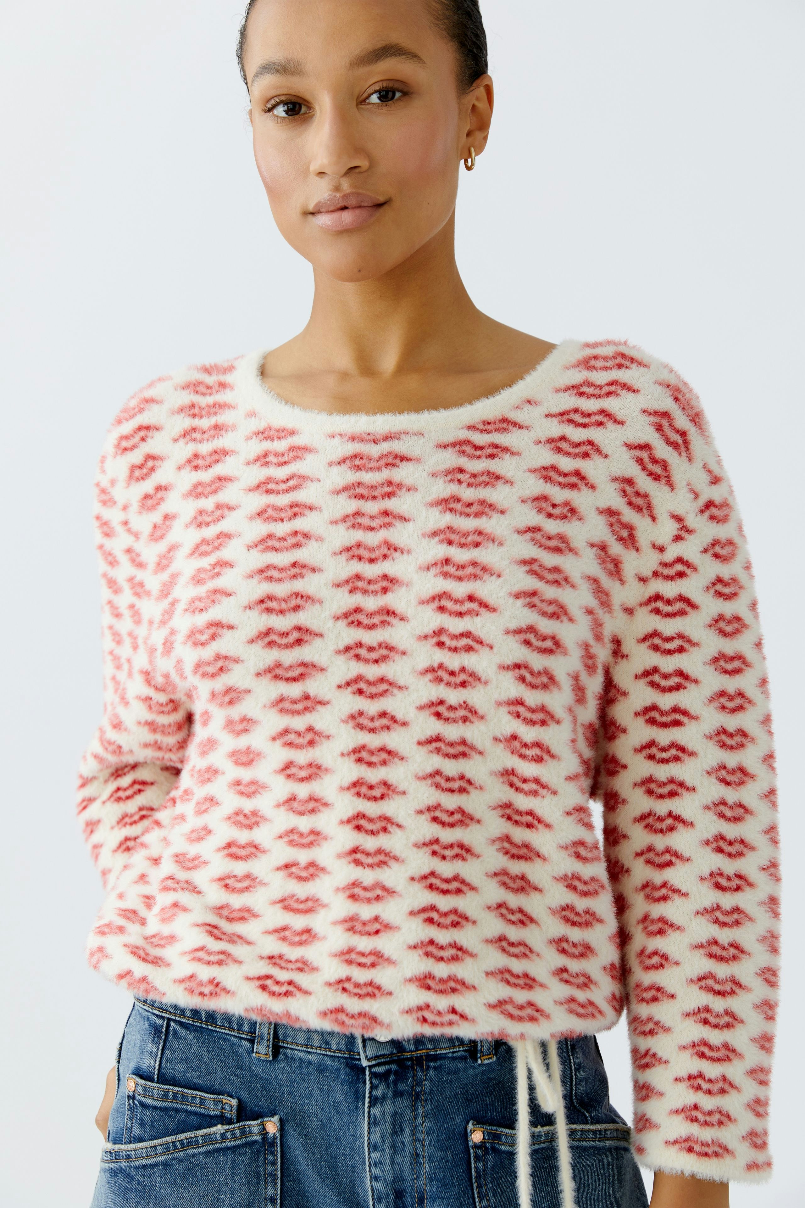 Casual women's pullover: A woman in a fluffy red and white patterned pullover with a relaxed fit.