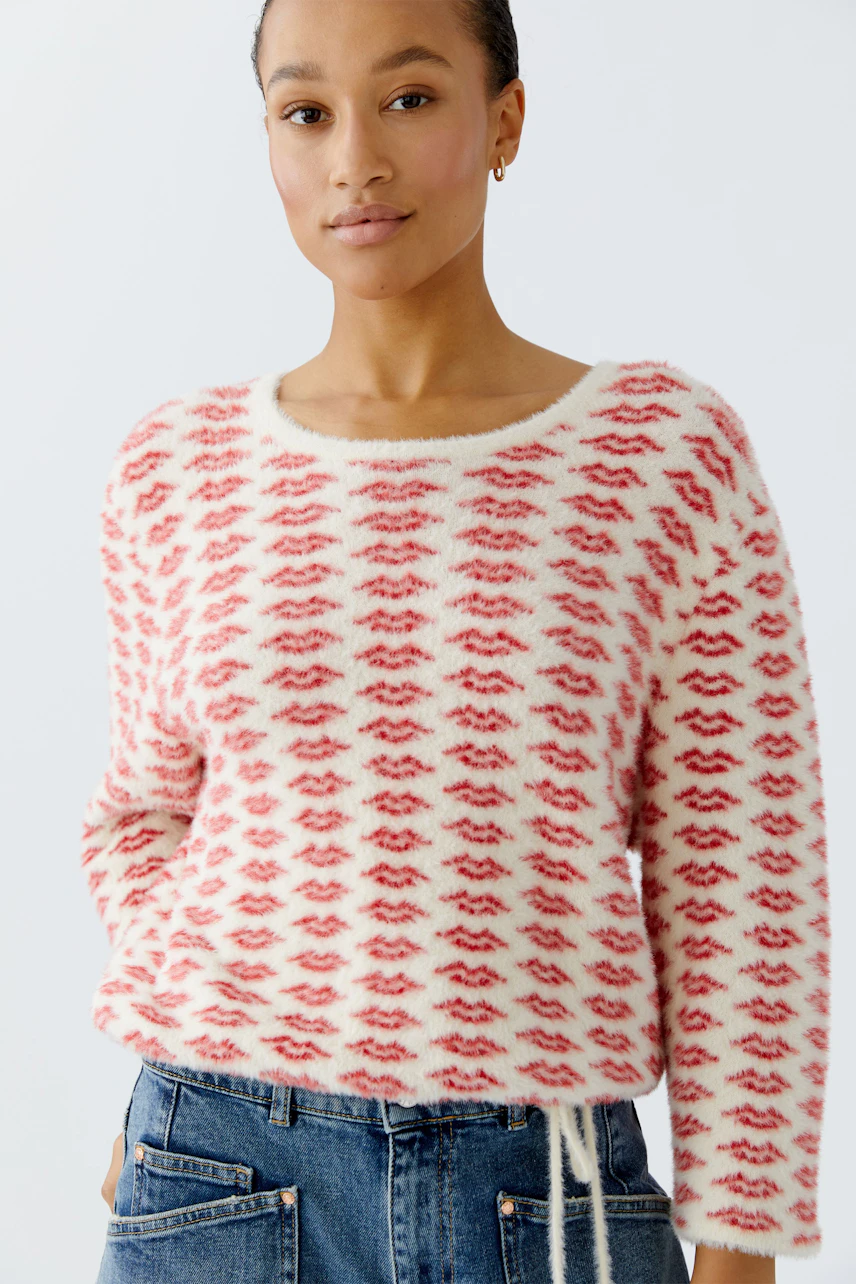 Casual women's pullover: A woman in a fluffy red and white patterned pullover with a relaxed fit.