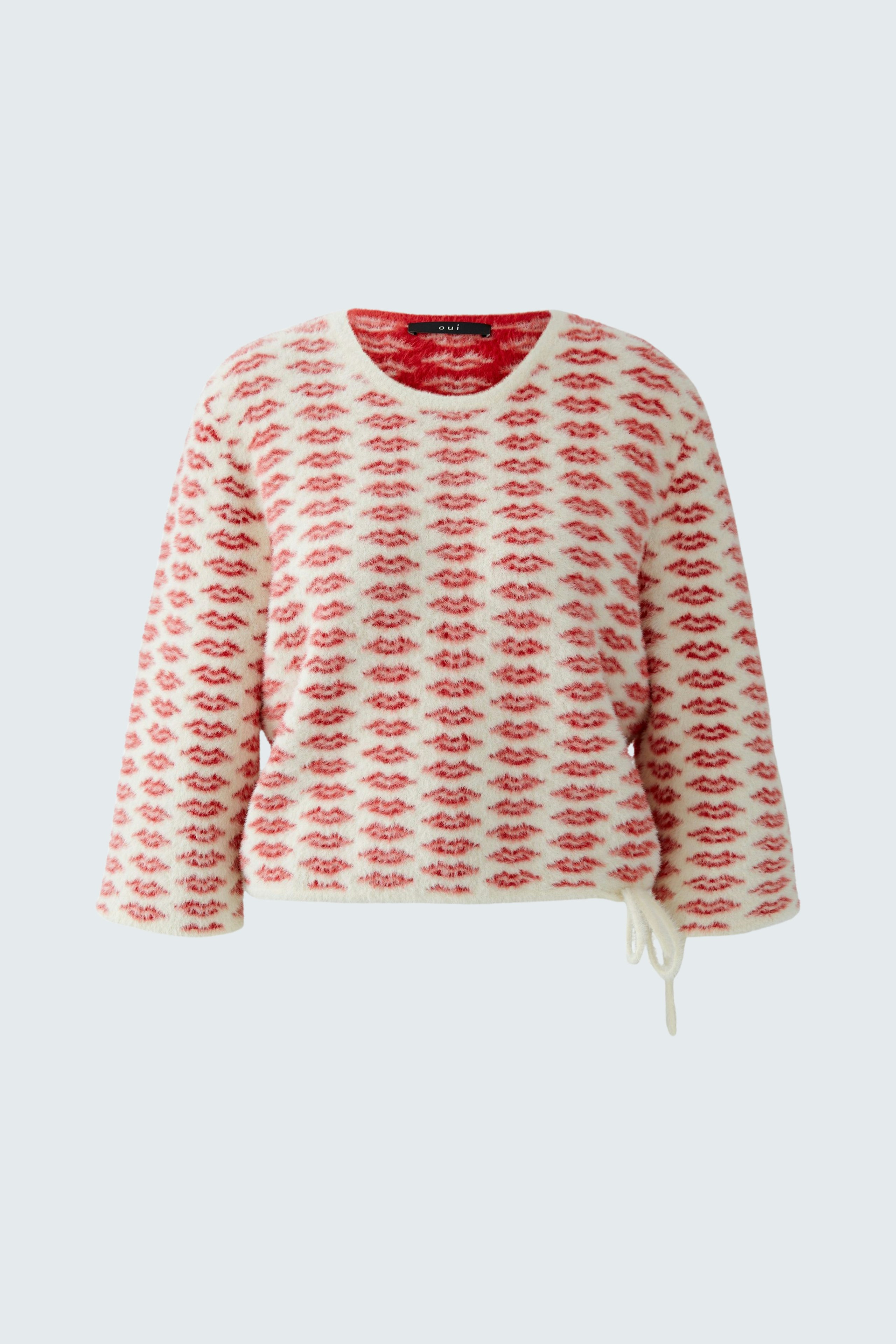 Casual women's pullover: A woman in a red and white patterned pullover with a relaxed fit.