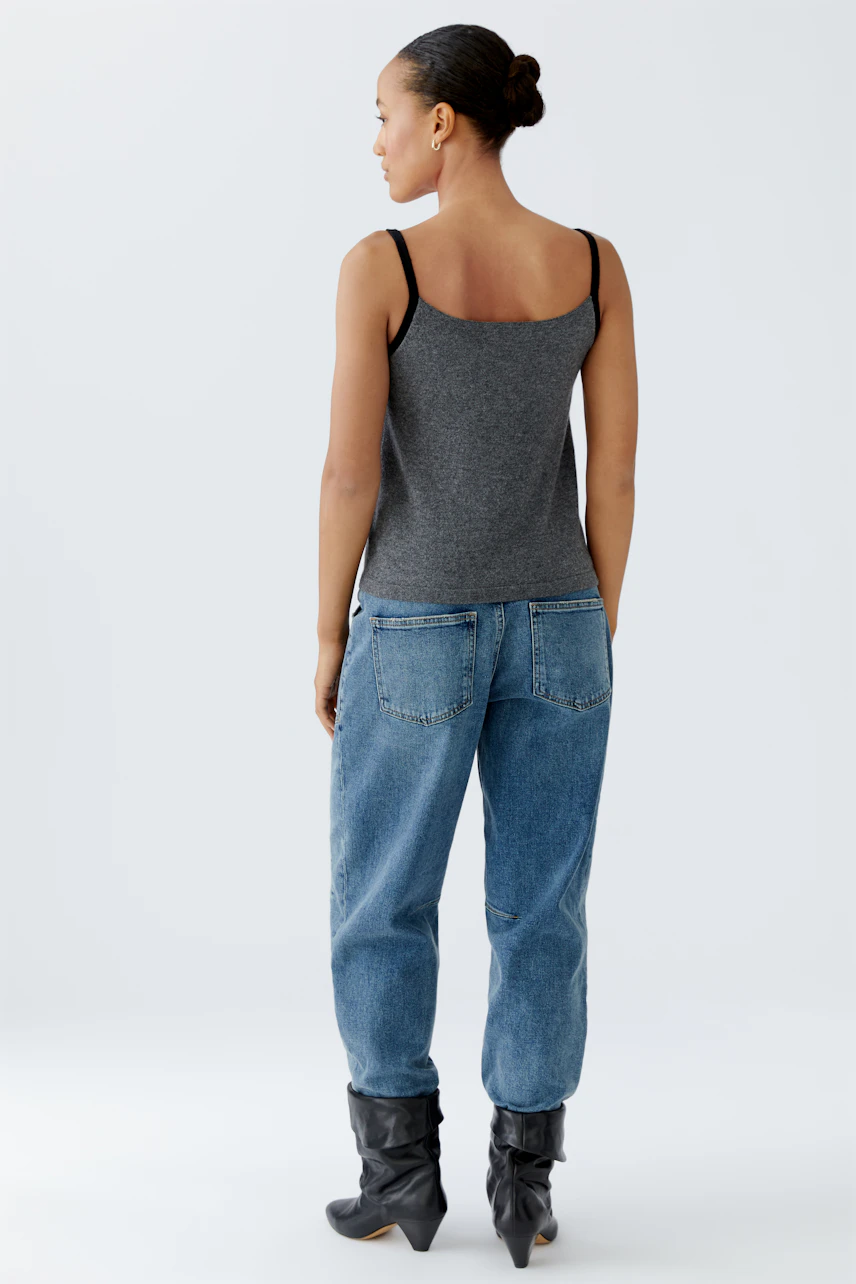 Damen-Top: Frau trägt ein graues, ärmelloses Top mit schmalen Trägern und lässigen Jeans.