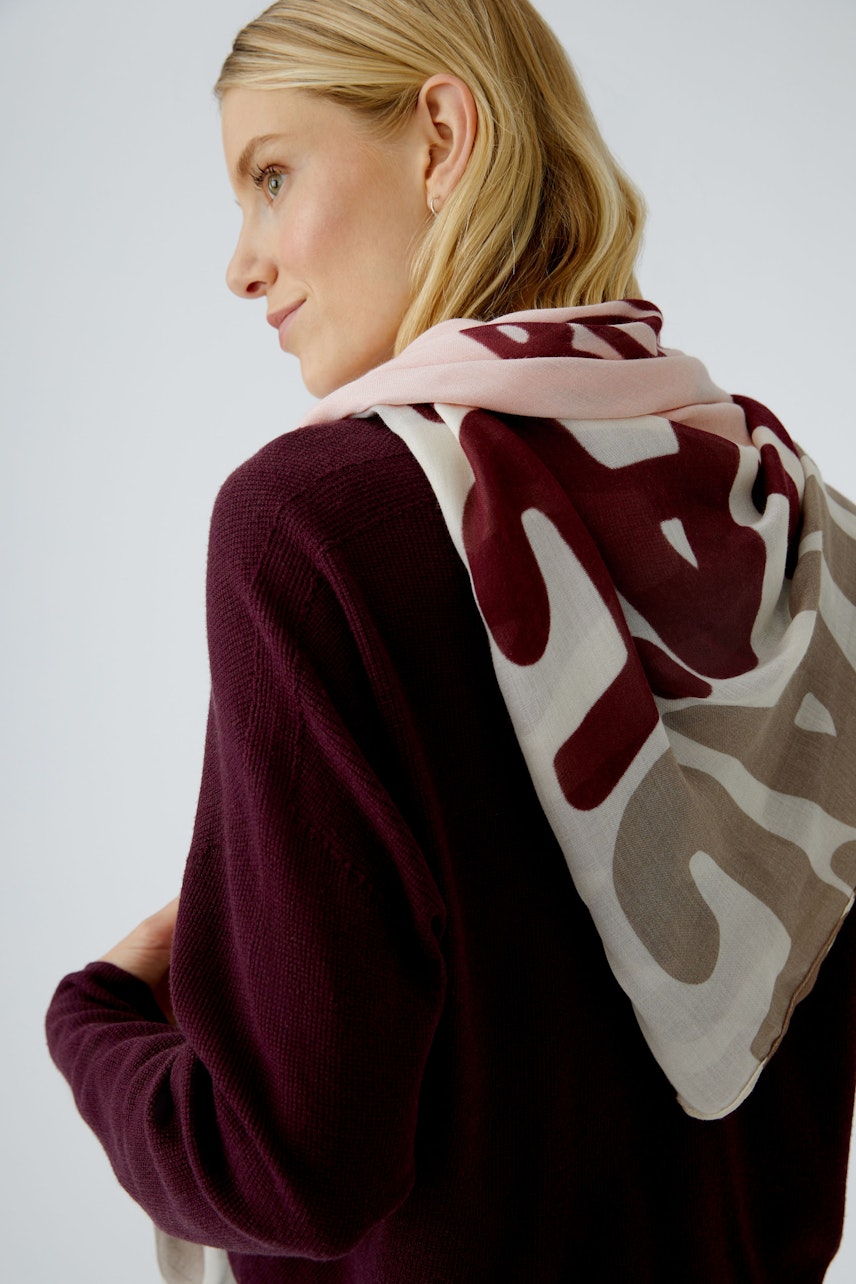 Damen-Pullover: Frau mit lila Strickpullover und buntem Schal, lässig und modern.
