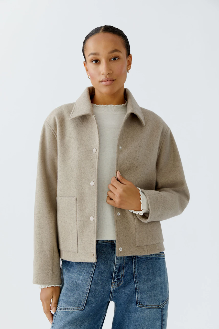 Casual women's jacket: Young woman in a beige jacket with pockets, paired with a light top and jeans.
