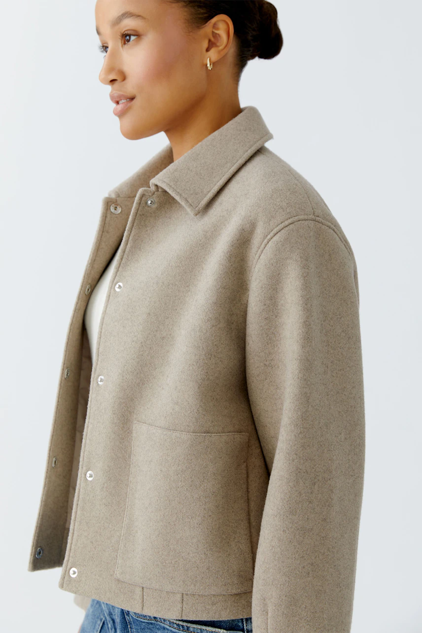 Casual women's jacket: A woman in a beige jacket with a collar and pockets, styled with denim.
