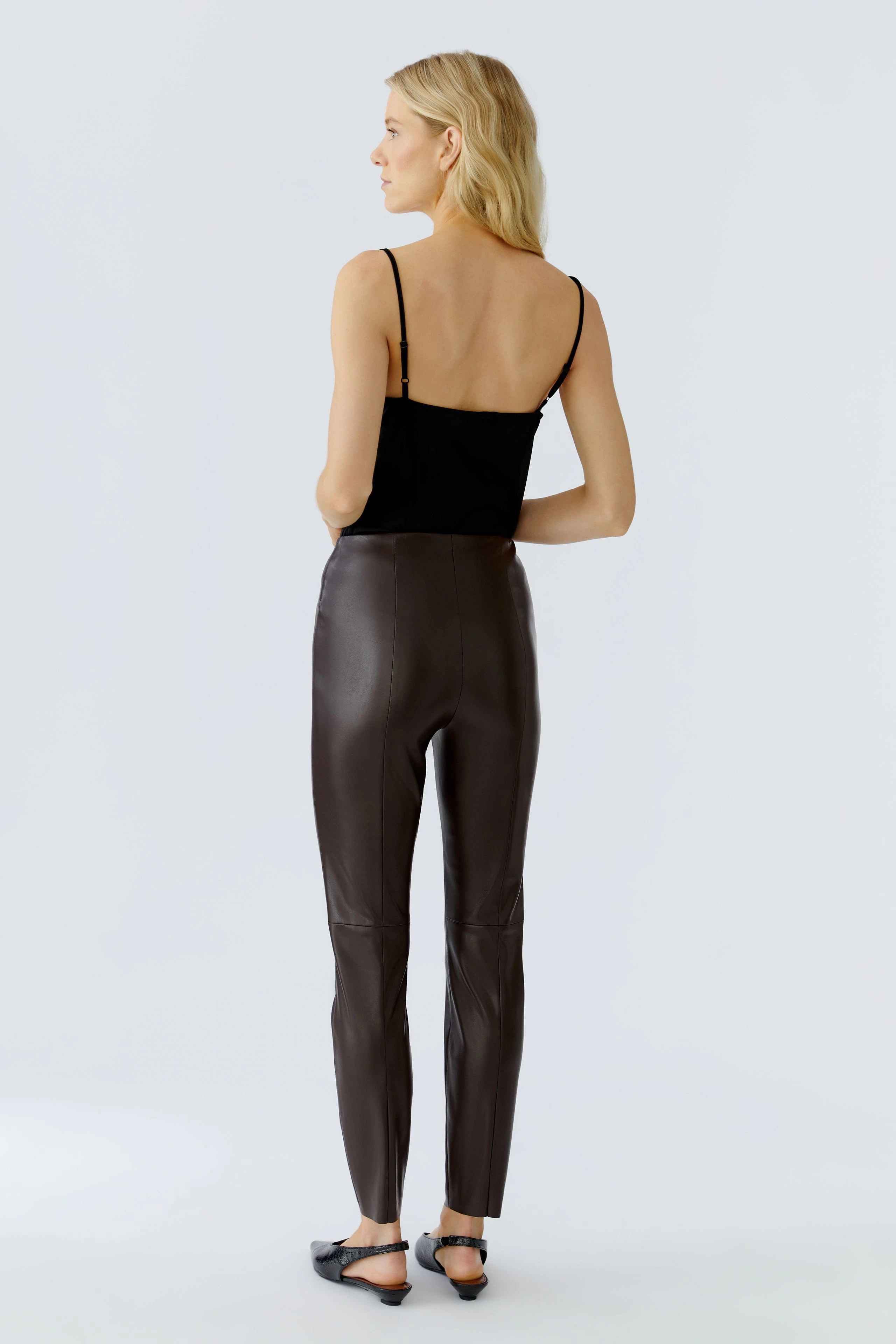 Stylish leggings: Woman in brown leggings and black top, showcasing a modern, casual look.