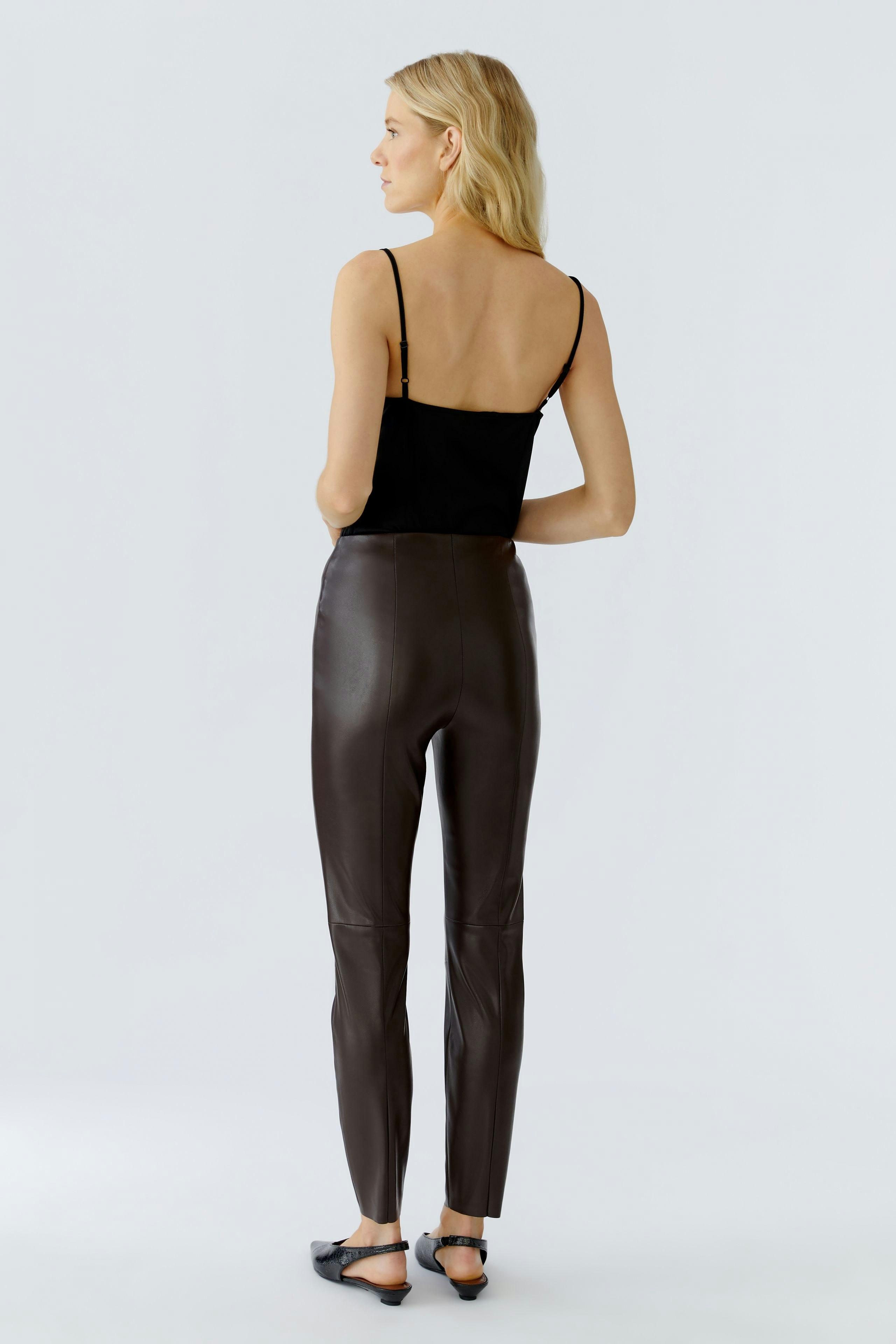 Stylish leggings: Woman in brown leggings and black top, showcasing a modern, casual look.
