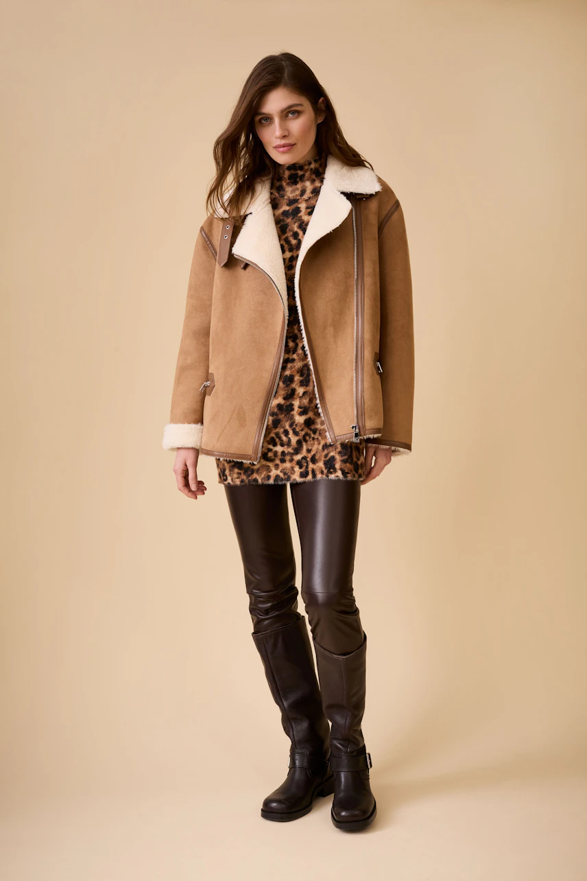 Stylish leggings: Young woman in black leggings paired with a chic animal print top and a cozy jacket.