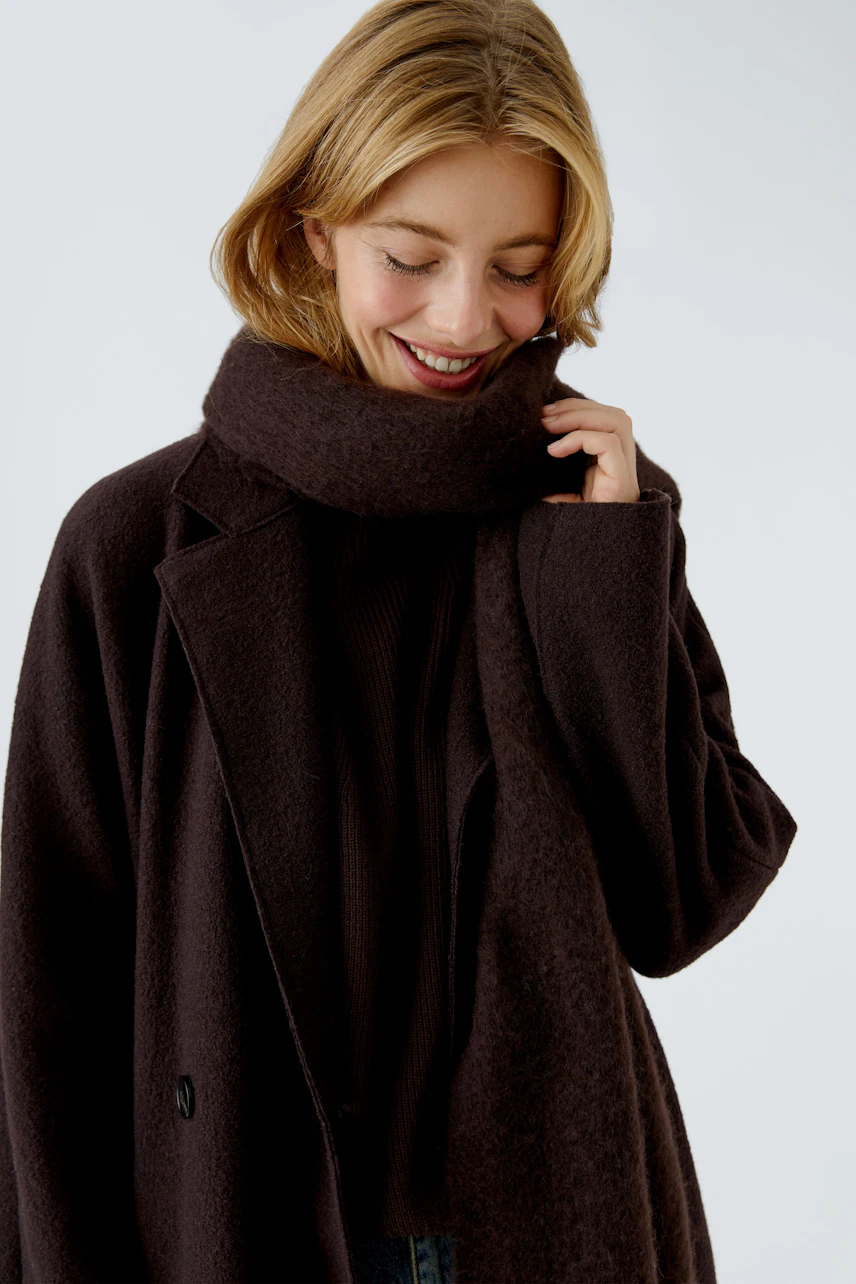 Cozy women's scarf in dark brown, styled with a matching coat, perfect for chilly days.