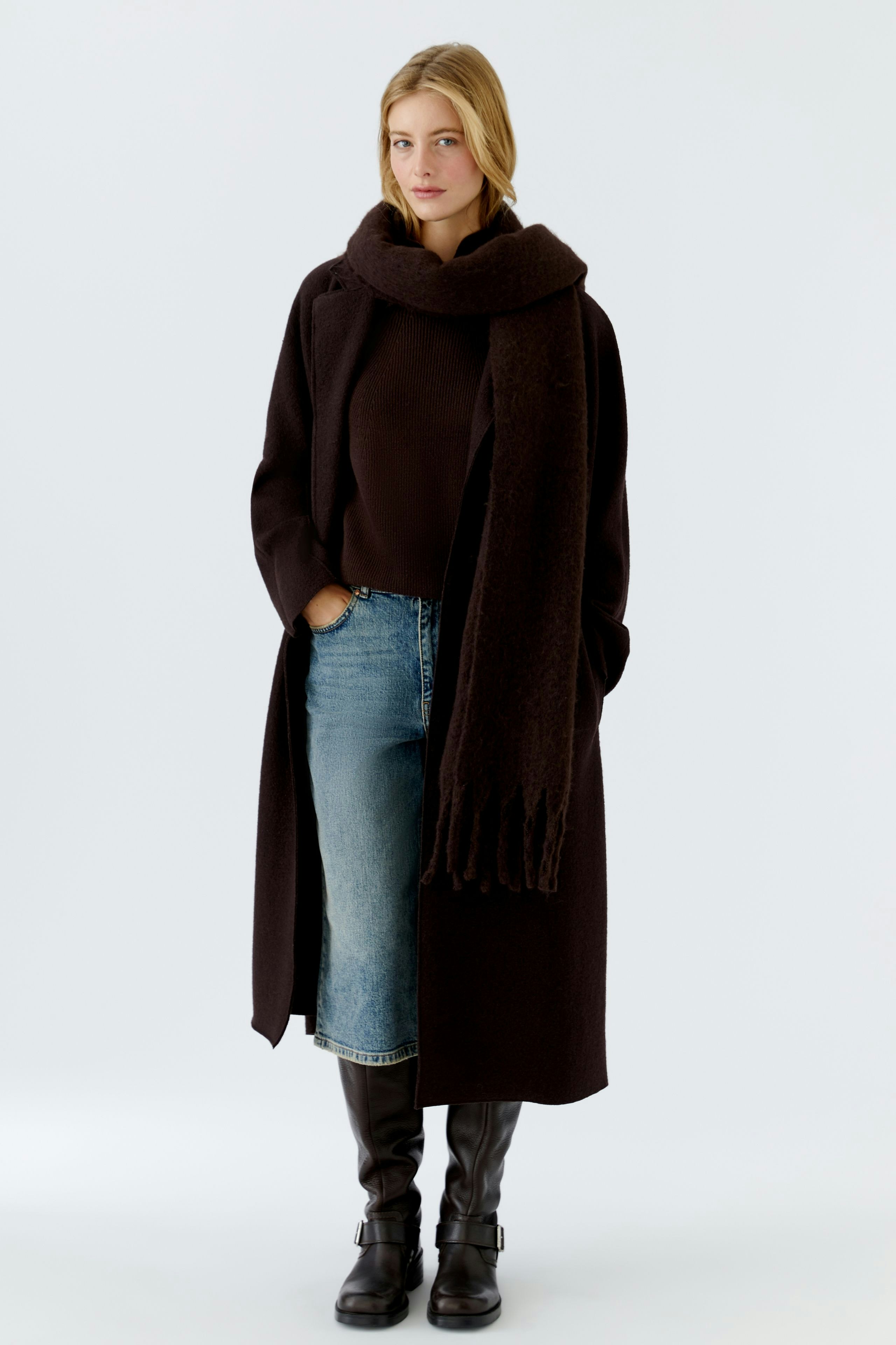 Cozy scarf worn by a woman, paired with a dark outfit and denim skirt.