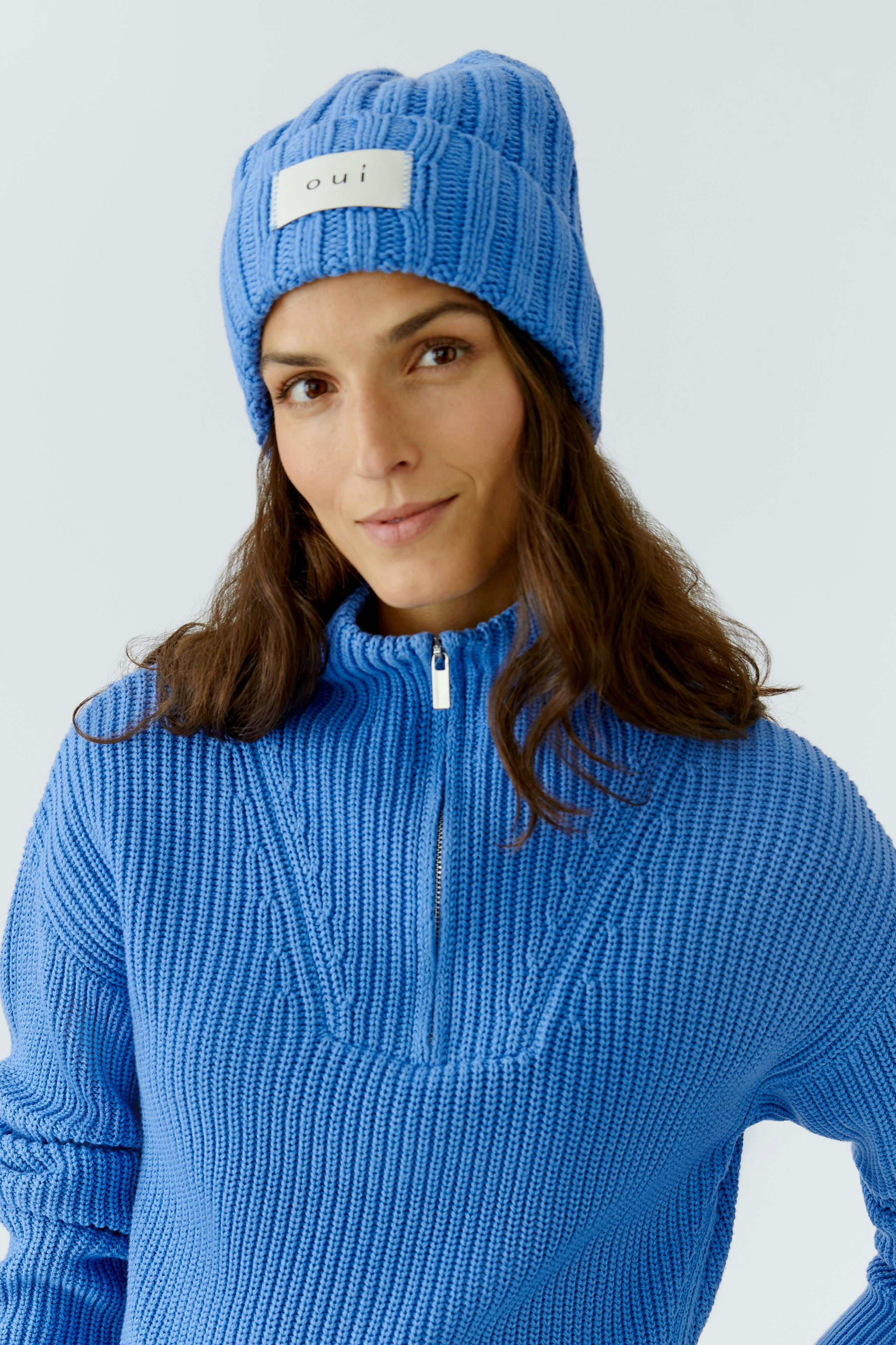Cozy women's beanie in bright blue, featuring a logo patch, perfect for casual wear.