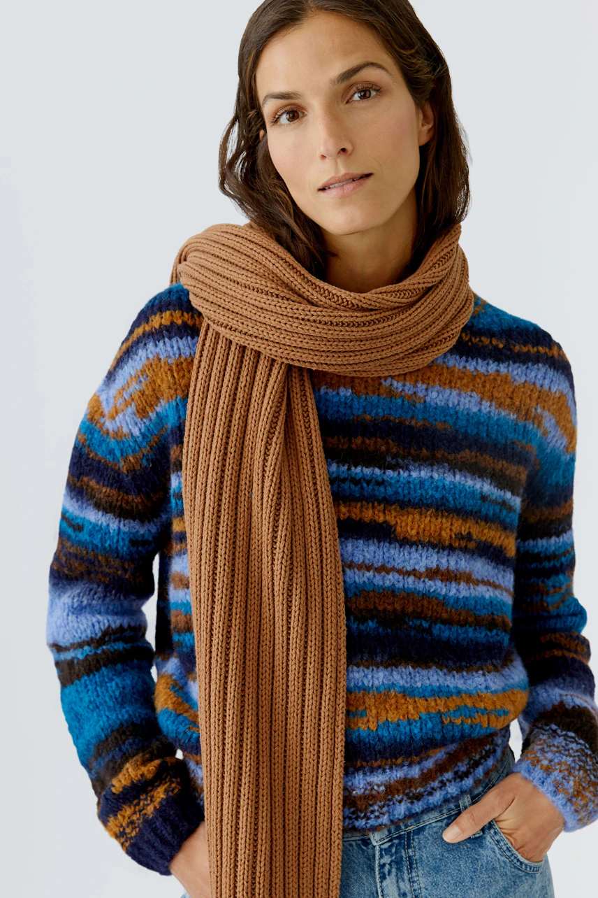 Cozy scarf worn by a woman, styled with a colorful pullover, perfect for casual outfits.
