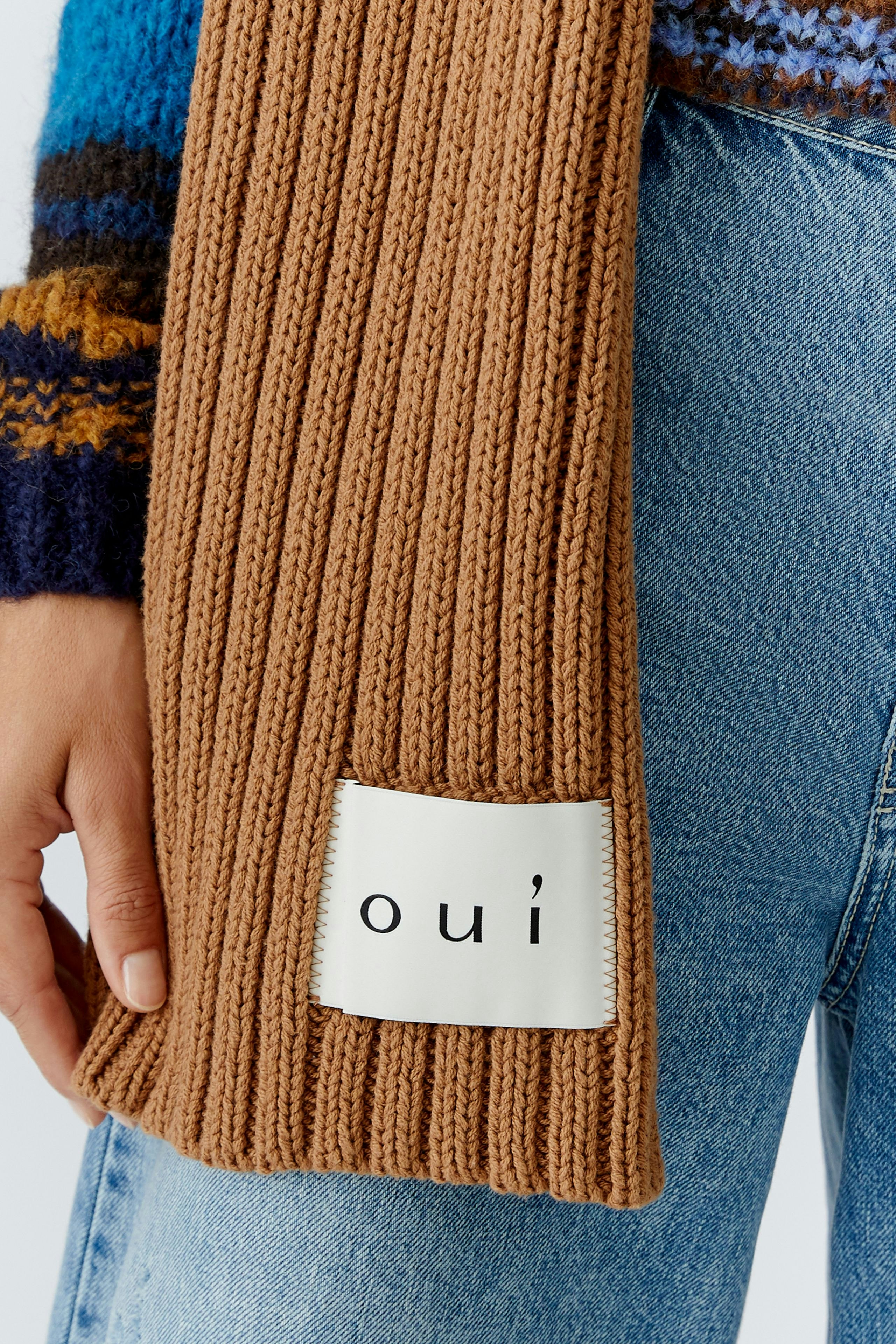 Cozy women's scarf in ribbed knit, featuring a logo patch, perfect for casual outfits.