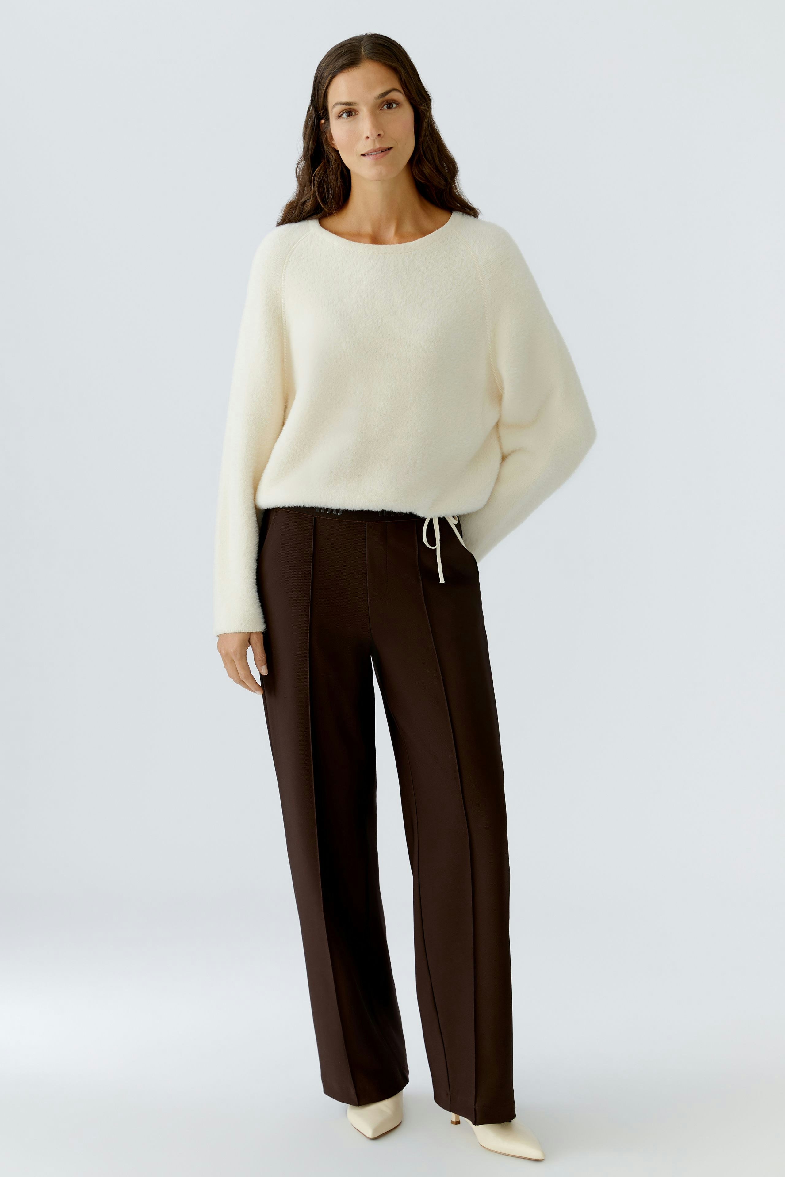 Casual women's trousers: A woman in brown trousers with a relaxed fit and drawstring detail.