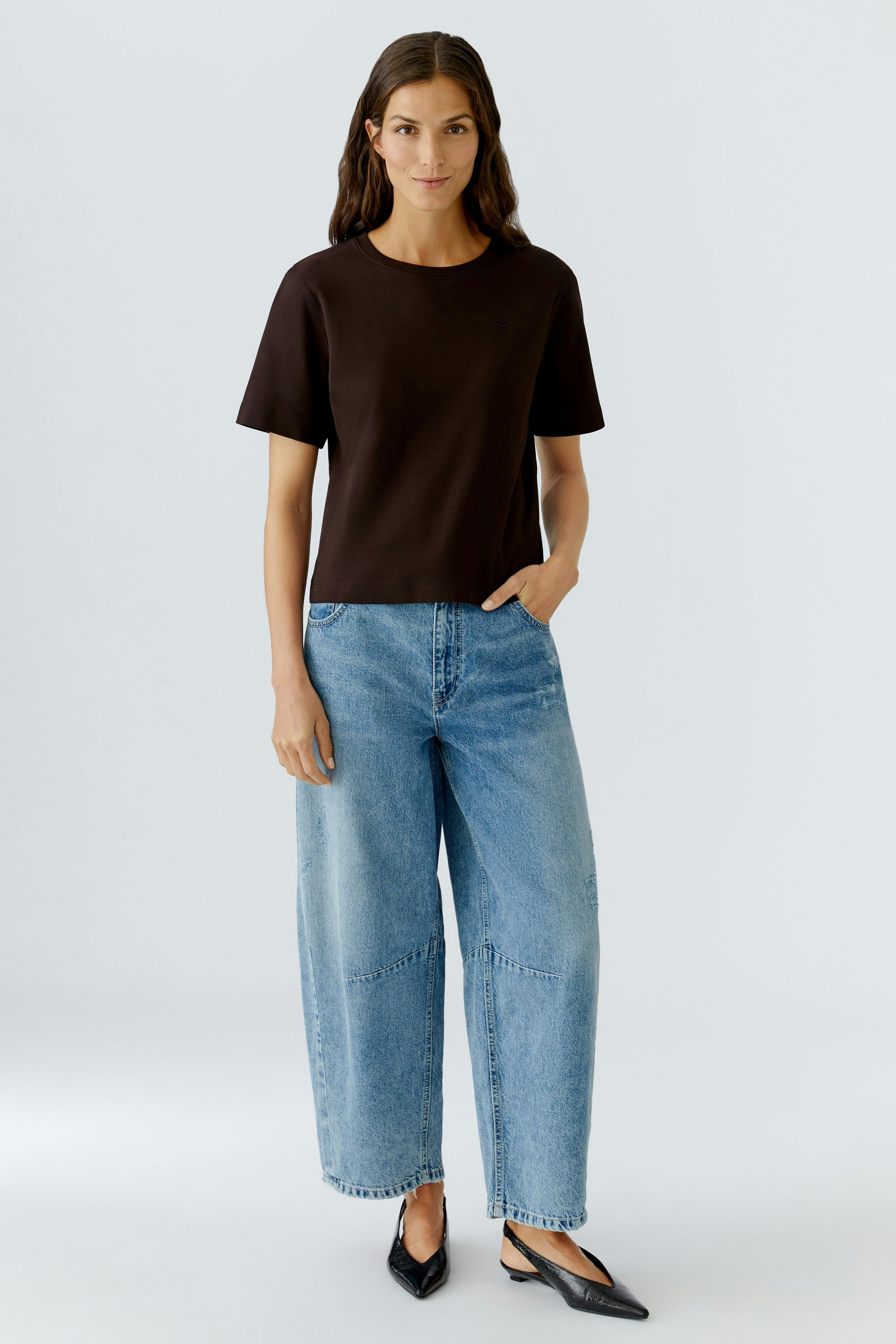 Casual women's T-shirt: A woman in a black T-shirt paired with relaxed-fit jeans.