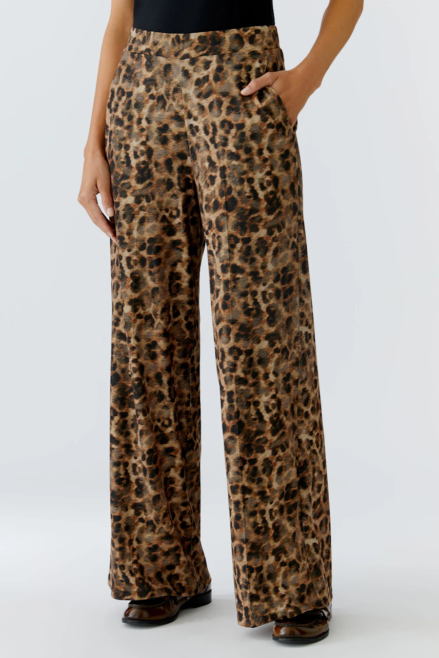 Bequeme Marlenehose: Frau trägt eine lässige Hose im Leo-Print mit weitem Bein und praktischen Taschen.