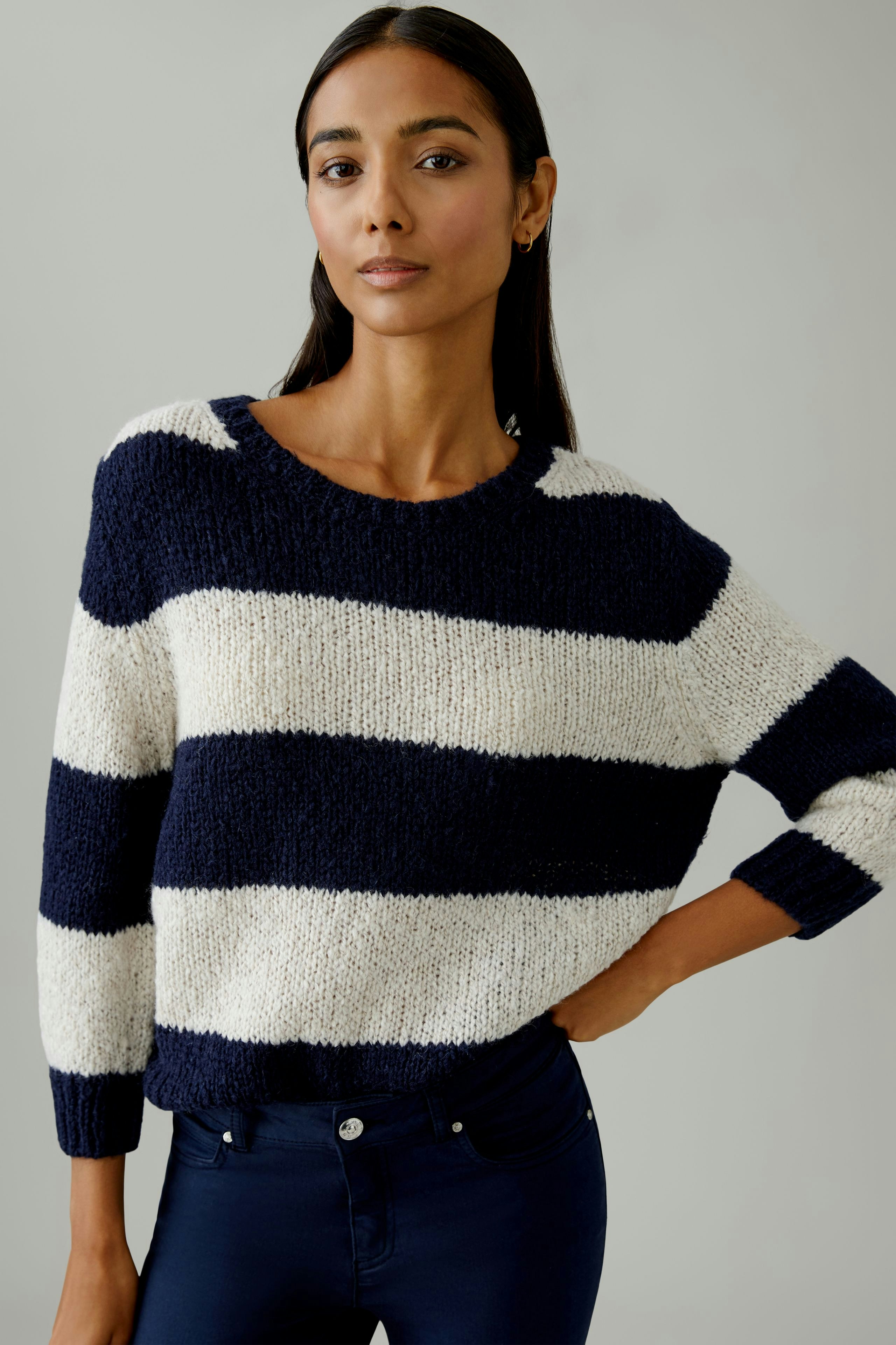 Damen-Pullover: Frau in gestreiftem Pullover mit breiten blauen und weißen Streifen, lässiger Look.