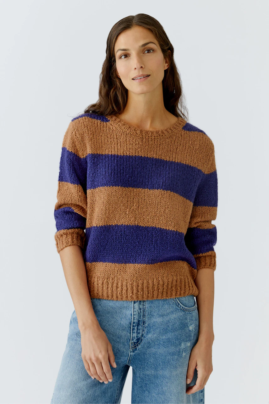 Casual women's pullover: A woman in a striped brown and purple pullover with rolled sleeves.