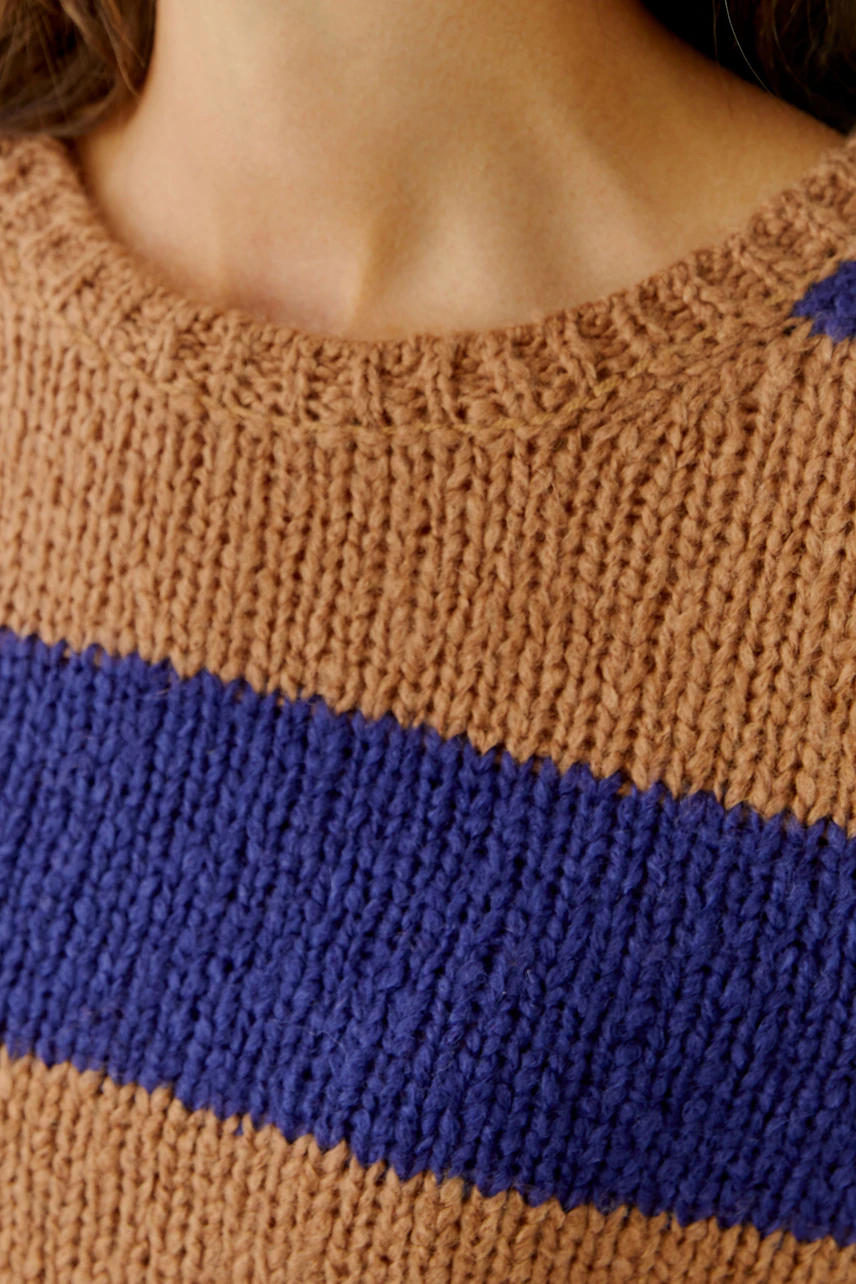 Casual women's pullover: Close-up of a woman wearing a brown and blue striped knit pullover.