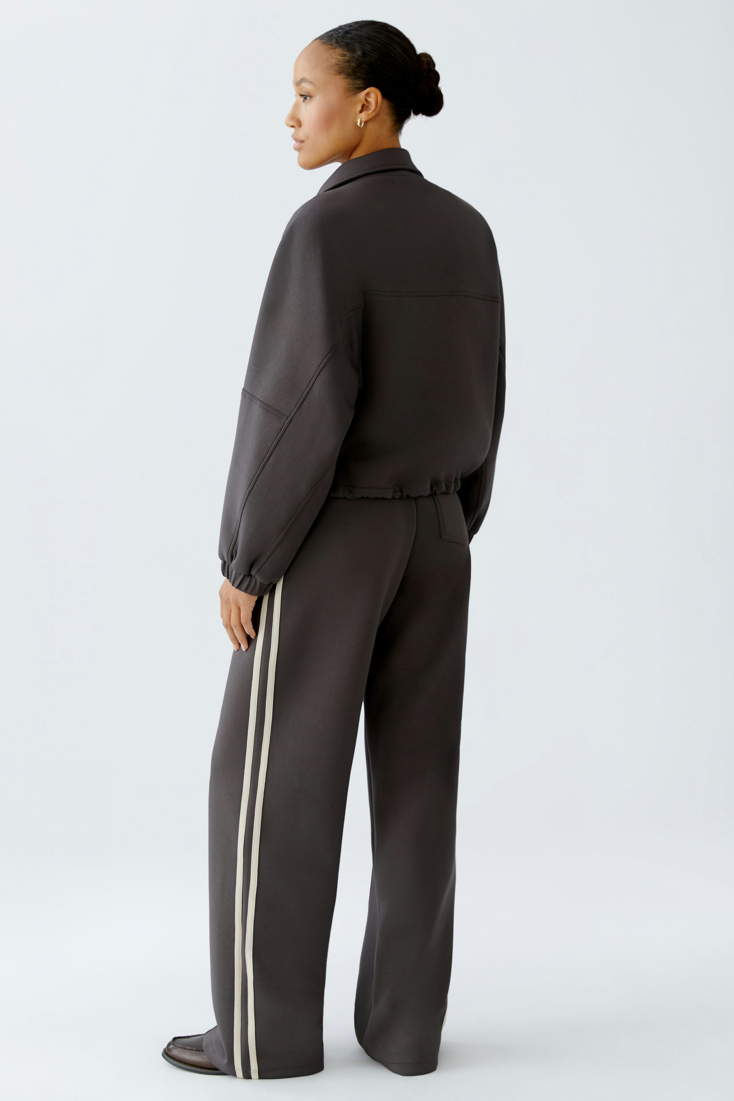 Casual women's jacket: A woman in a dark jacket with a relaxed fit and sporty details.