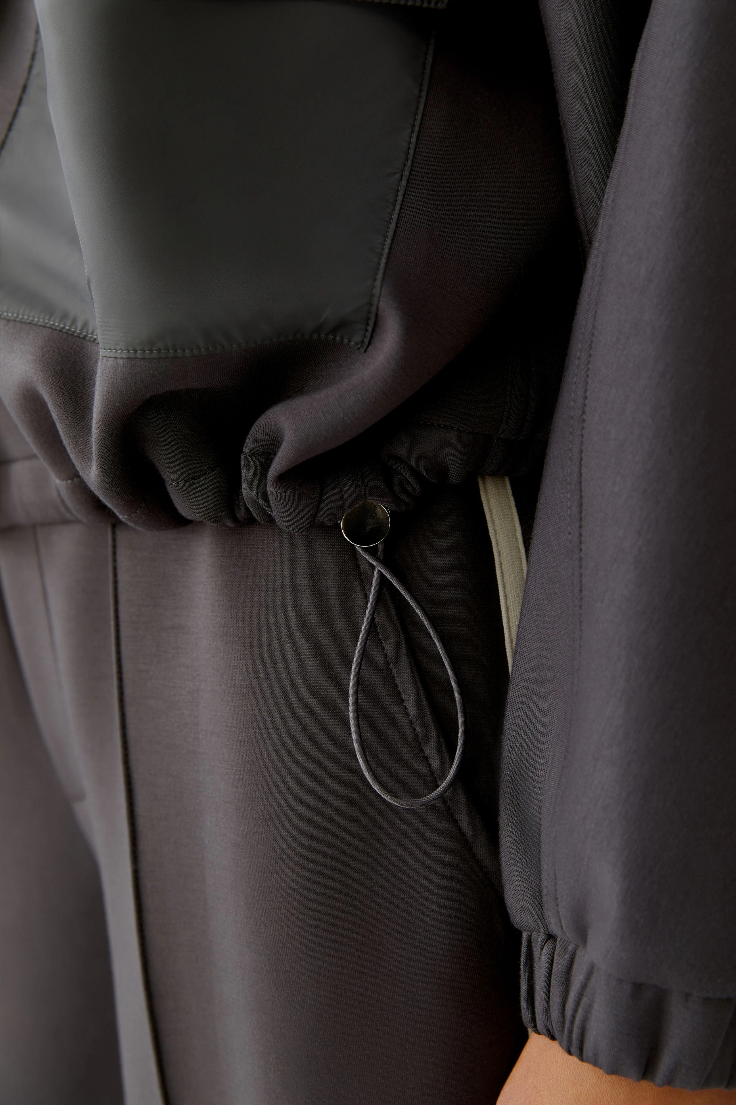 Casual women's jacket with a drawstring detail, showcasing a modern and relaxed style.