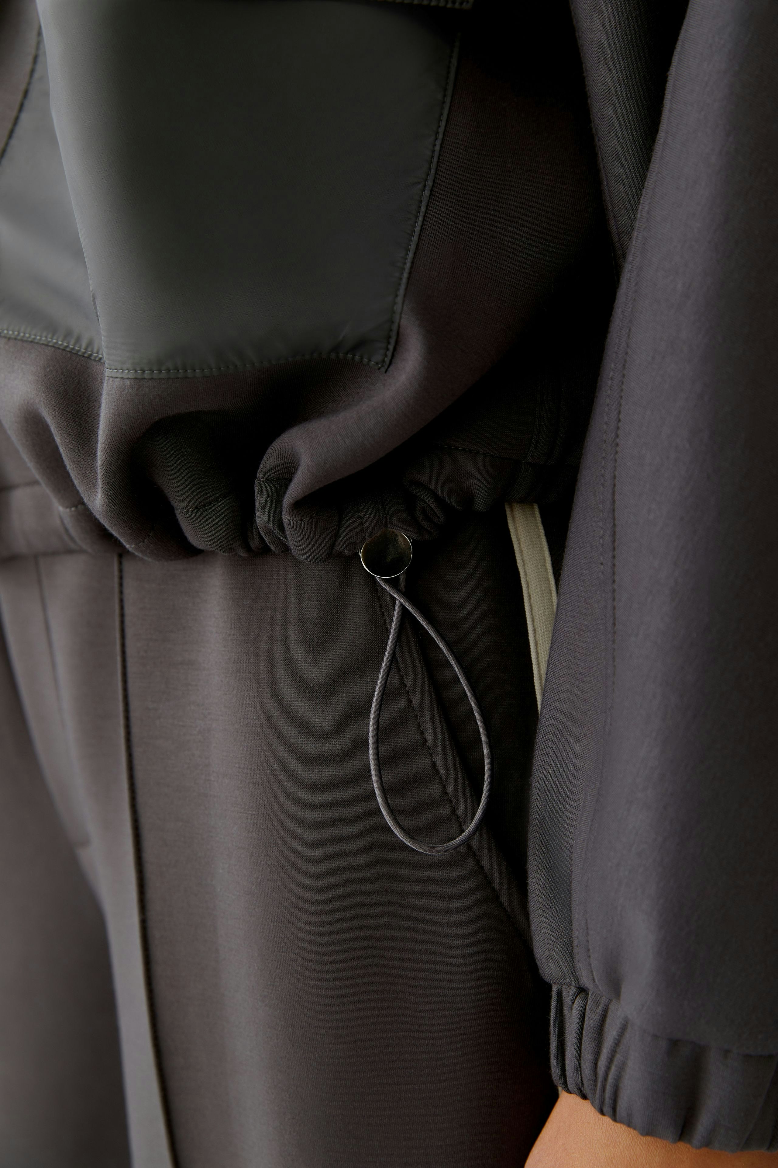 Casual women's jacket with a drawstring detail, showcasing a modern and relaxed style.