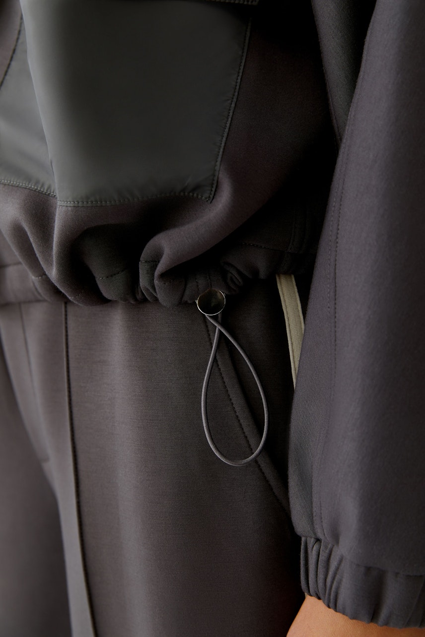 Moderne Damen-Jacke: Frau in lässiger Jacke mit elastischem Bund und praktischen Details.
