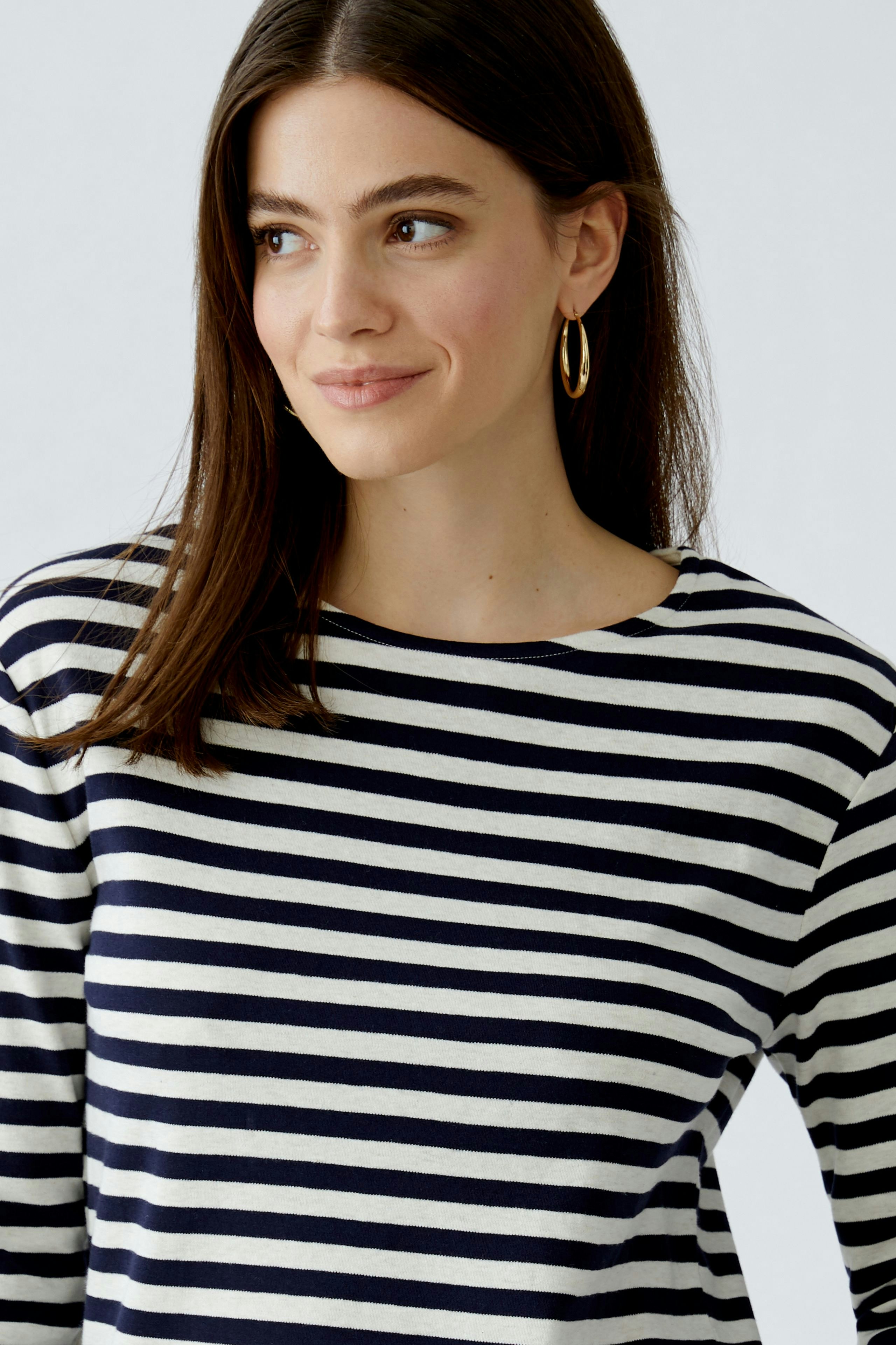 Casual women's T-shirt: Woman in a striped top with a relaxed fit and round neckline.