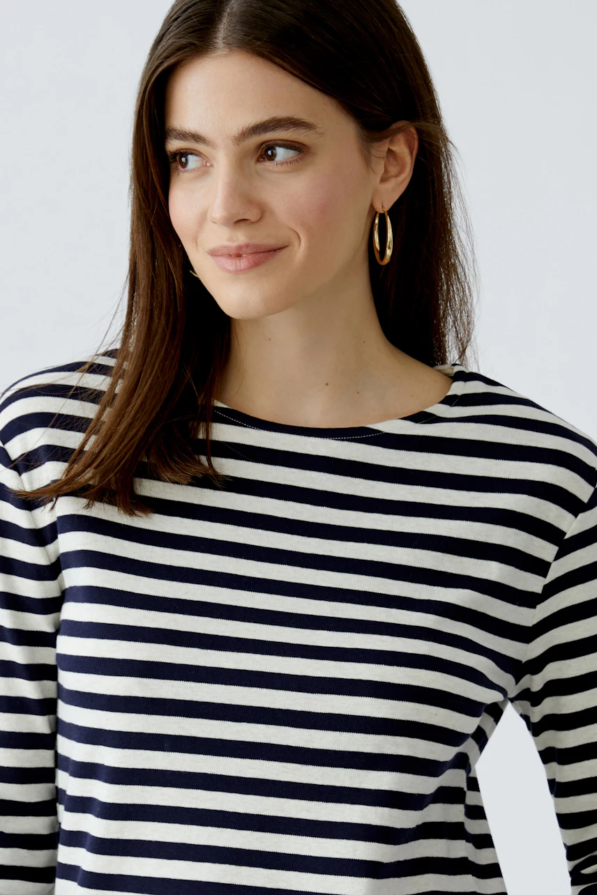 Casual women's T-shirt: Woman in a striped top with a relaxed fit and round neckline.