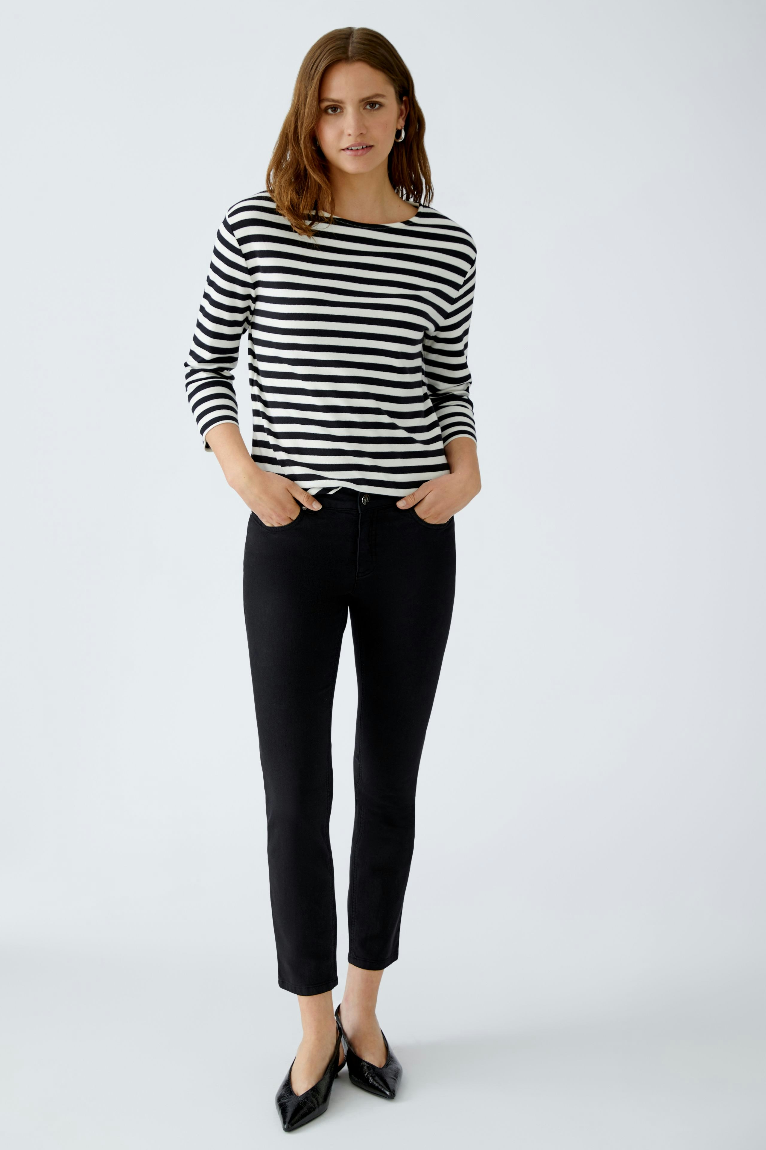 Casual women's T-shirt: Young woman in a striped black and white top with three-quarter sleeves.