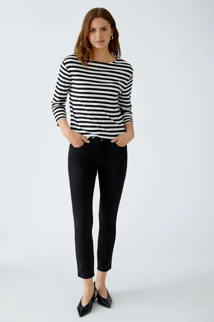 Casual women's T-shirt: Young woman in a striped black and white top with three-quarter sleeves.