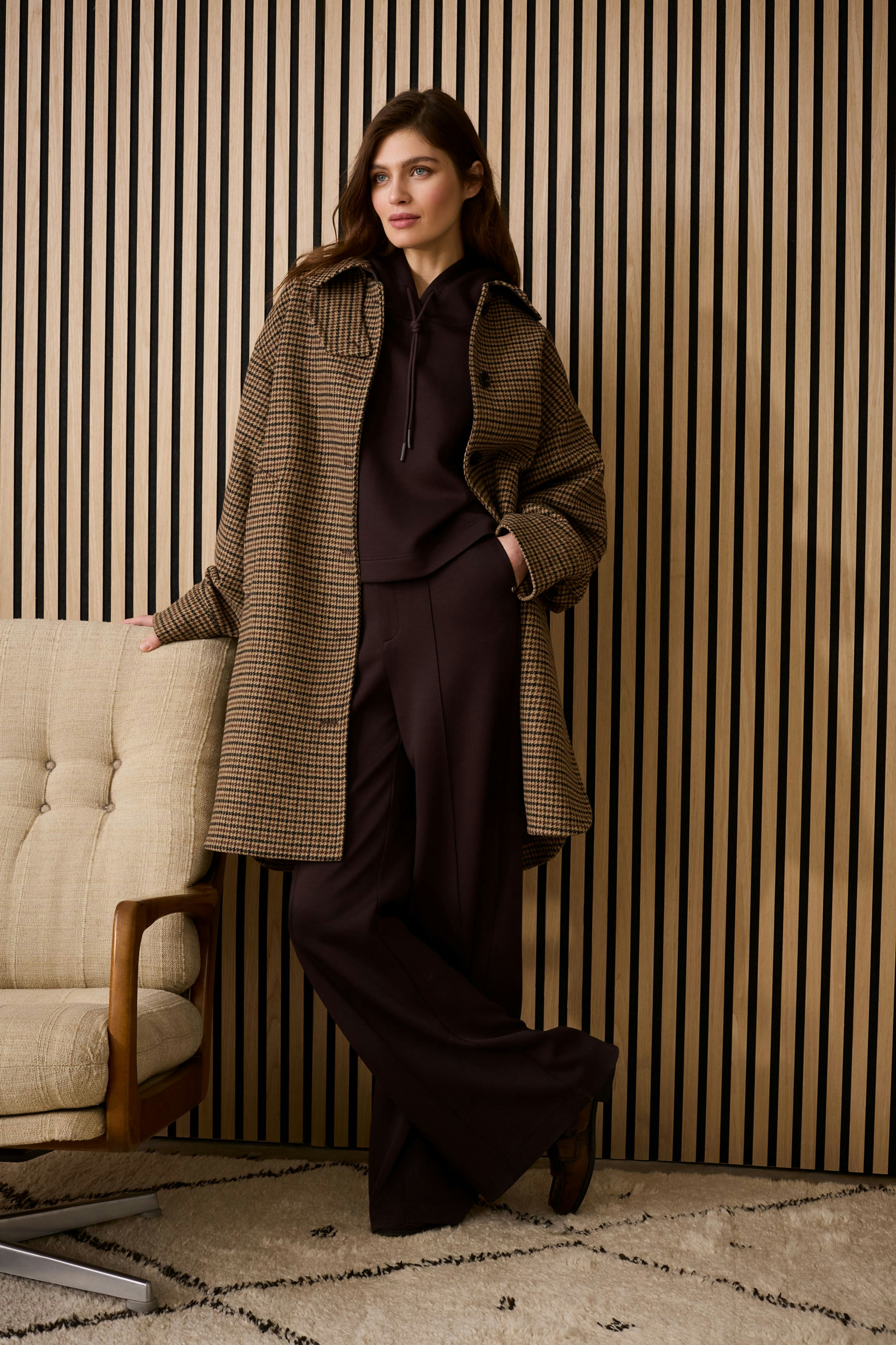 Casual women's pants: A woman in brown wide-leg pants paired with a stylish oversized coat.