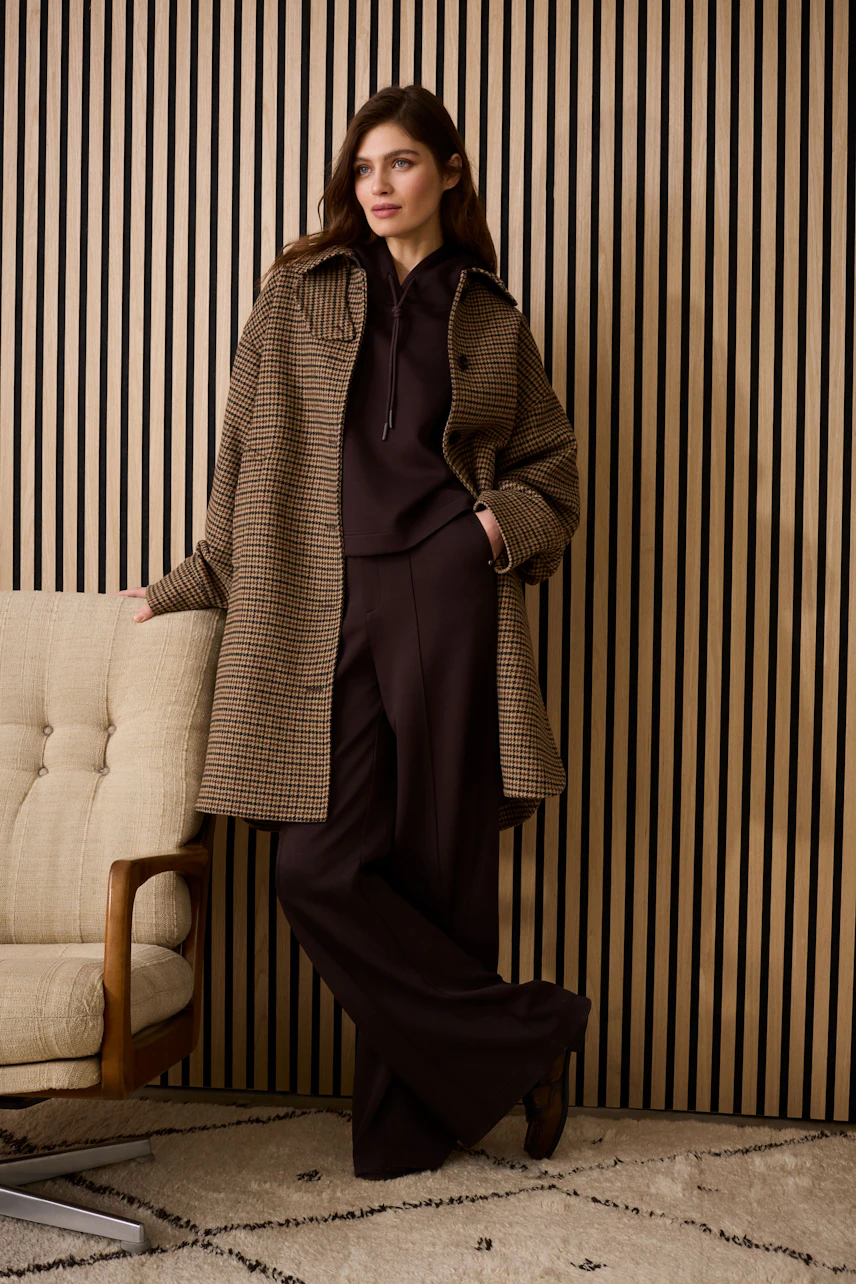 Casual women's pants: A woman in brown wide-leg pants paired with a stylish oversized coat.