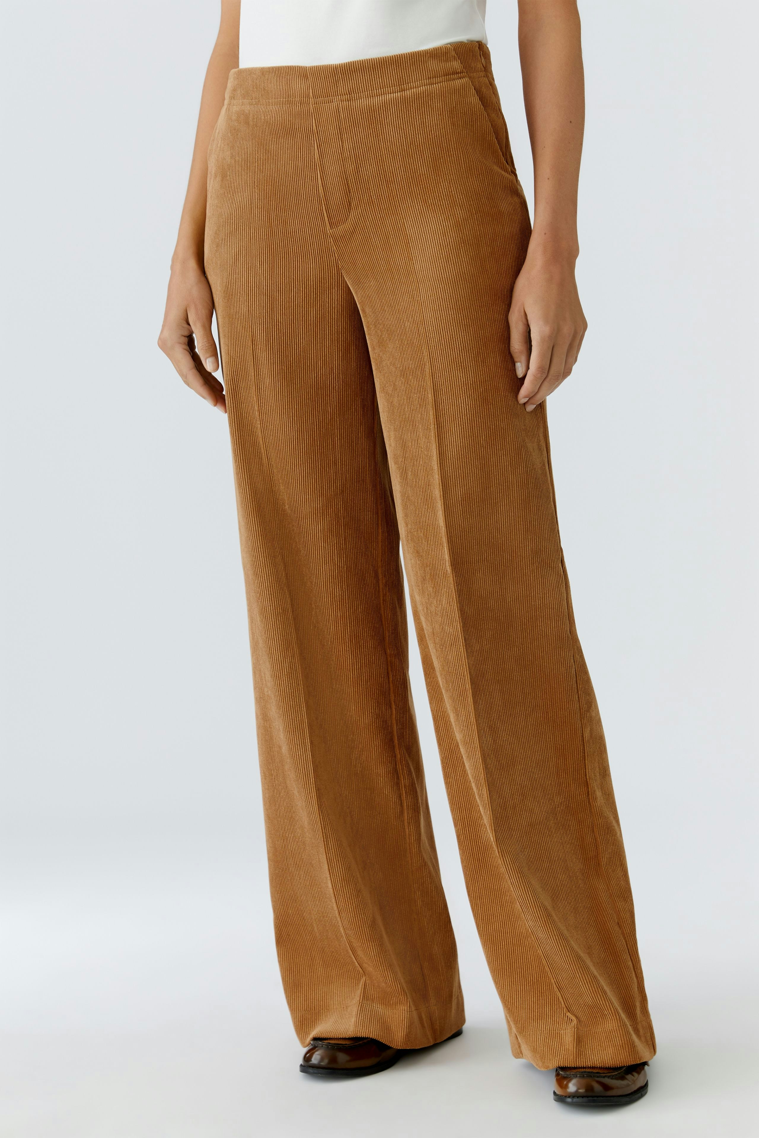 Casual women's cord pants in warm brown, featuring a relaxed fit and soft texture.