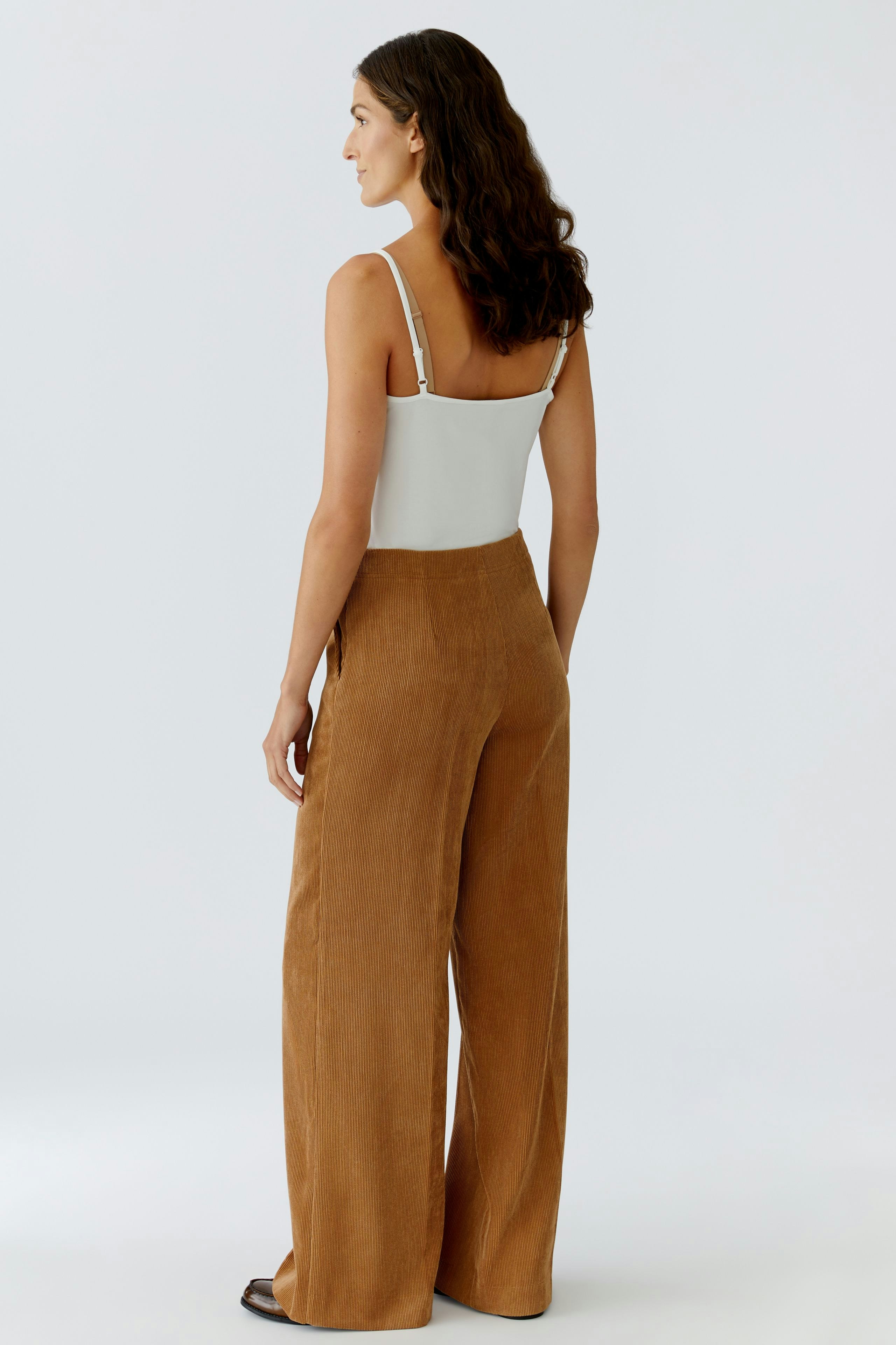 Casual women's cord trousers: A woman in brown corduroy pants, showcasing a relaxed fit and soft texture.