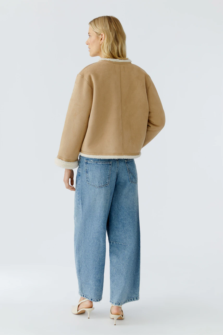 Casual women's faux leather jacket: A woman in a beige jacket with a soft lining and relaxed fit.