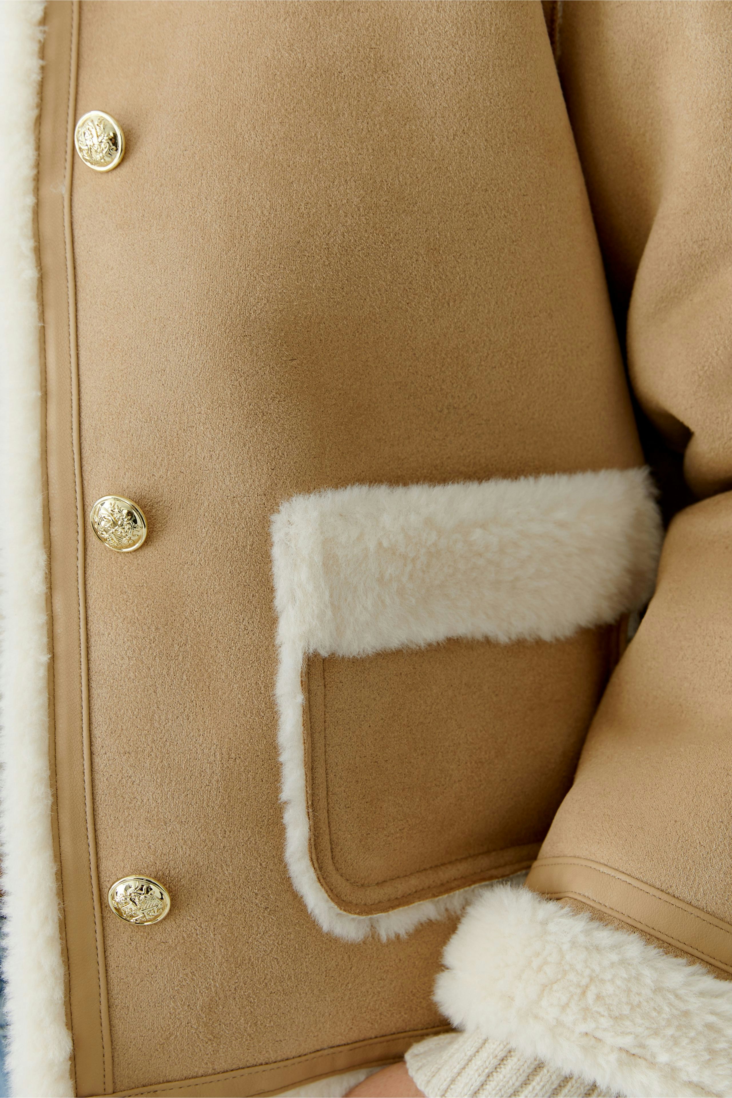 Stylish women's faux leather jacket with soft lining and gold buttons, perfect for casual wear.