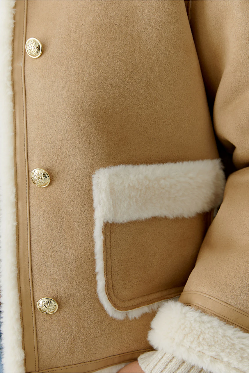 Stylish women's faux leather jacket with soft lining and gold buttons, perfect for casual wear.