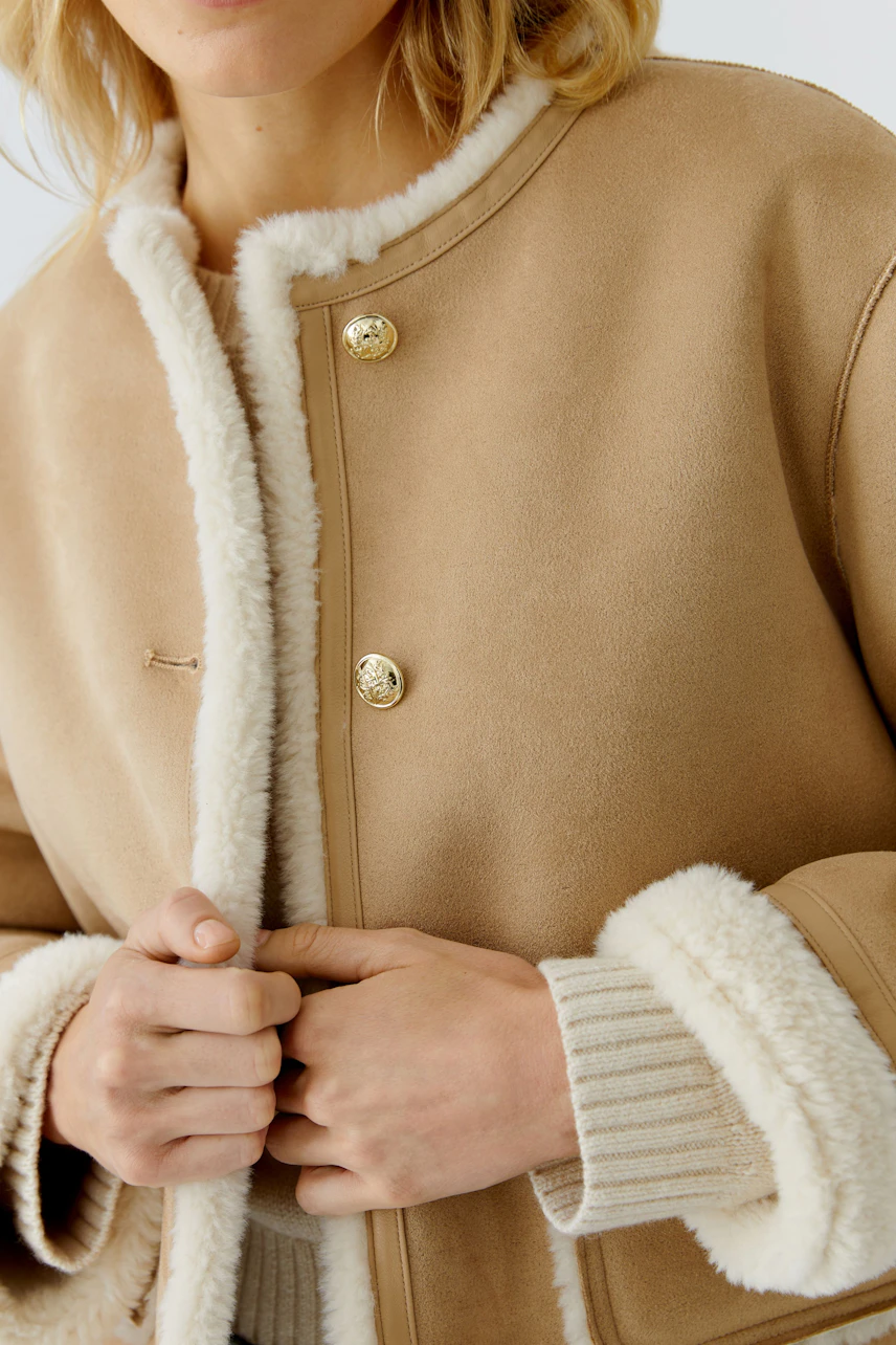 Stylish women's faux leather jacket with soft lining and gold buttons, perfect for casual wear.