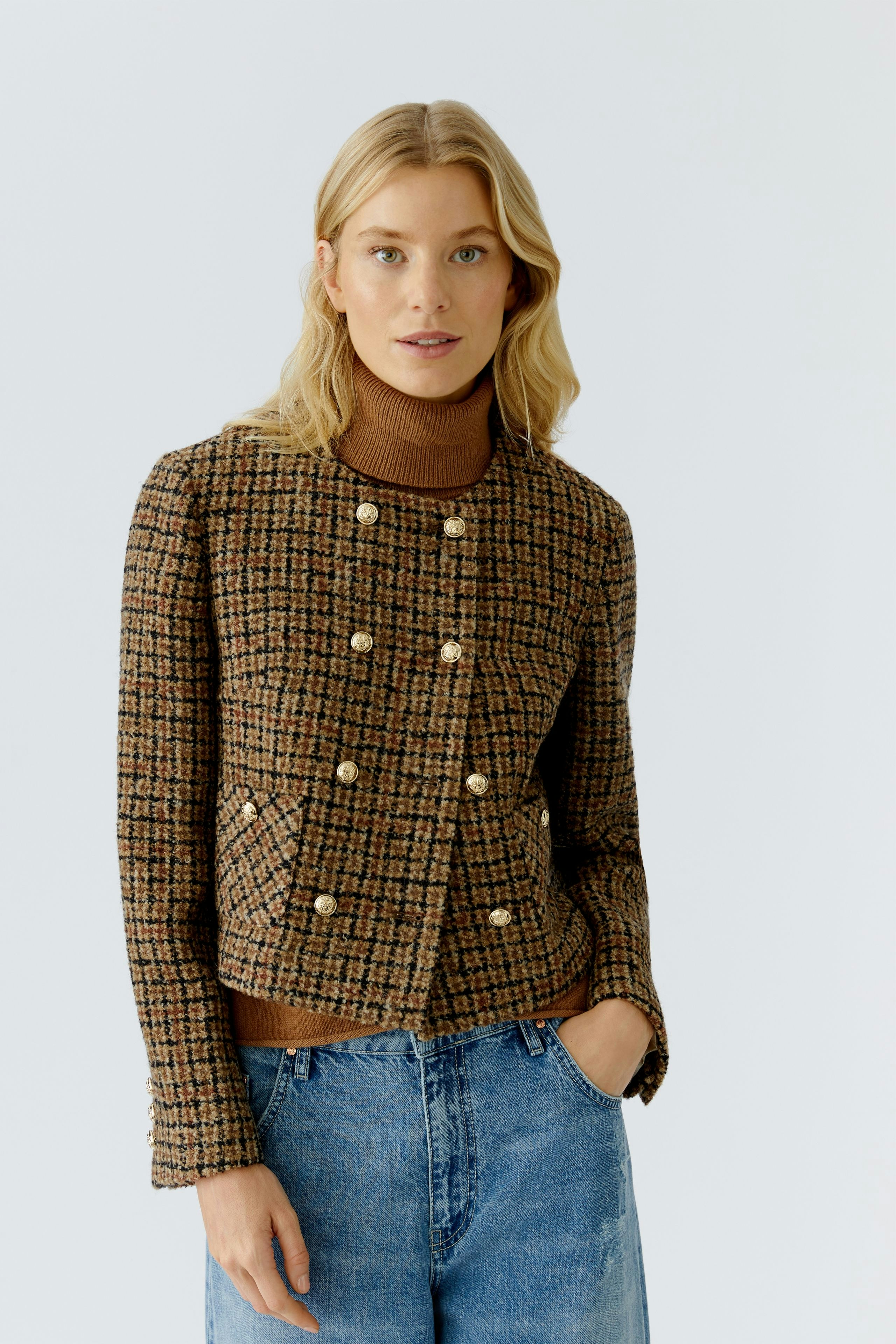 Stylish women's jacket: A woman in a brown checkered jacket with buttons, paired with a turtleneck.