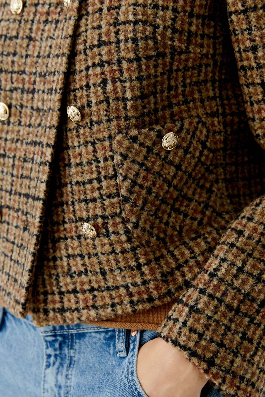 Stylish women's jacket in a brown check pattern with gold buttons and pockets.