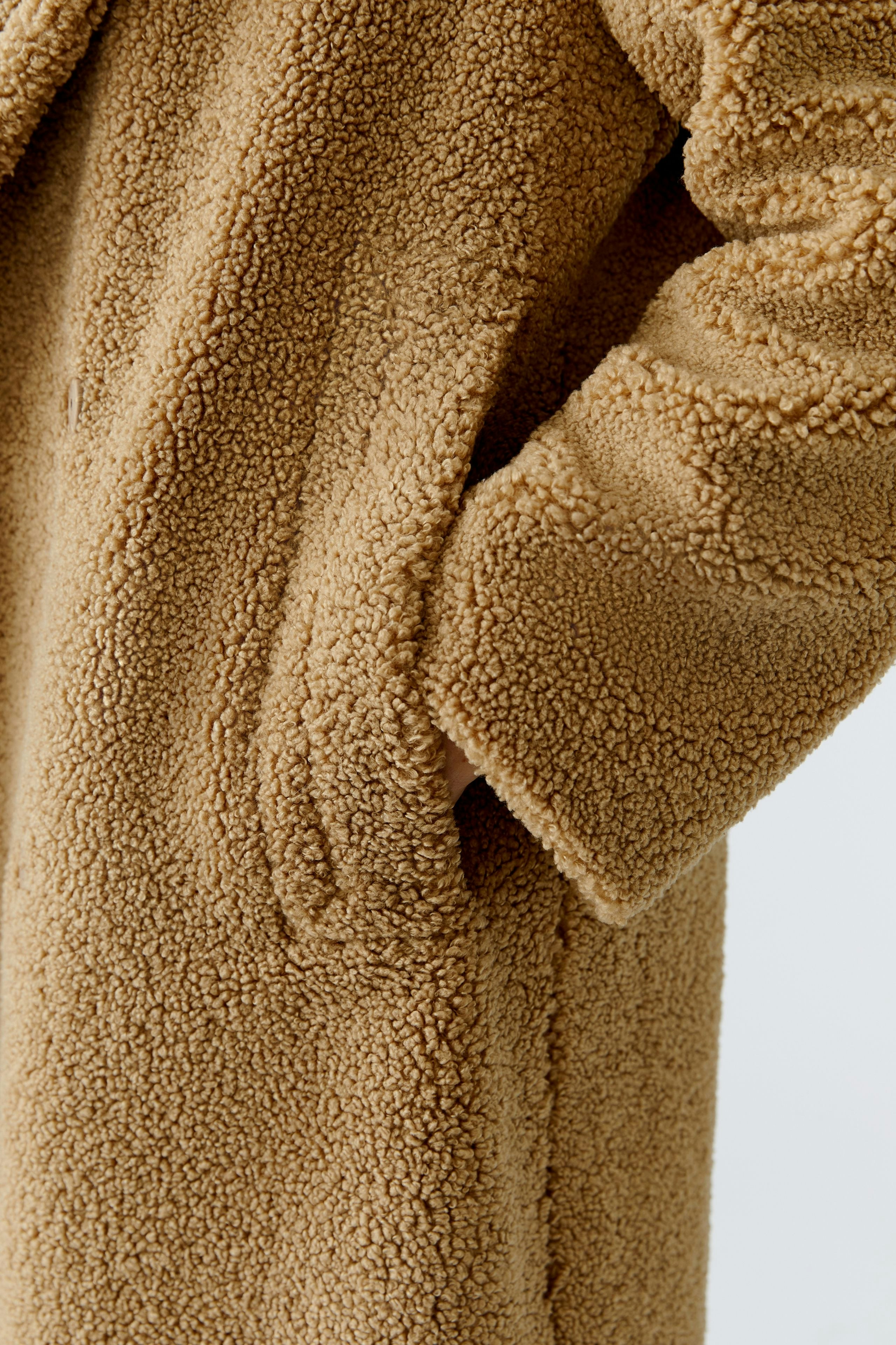 Cozy women's winter coat in soft teddy fabric with pockets, perfect for chilly days.