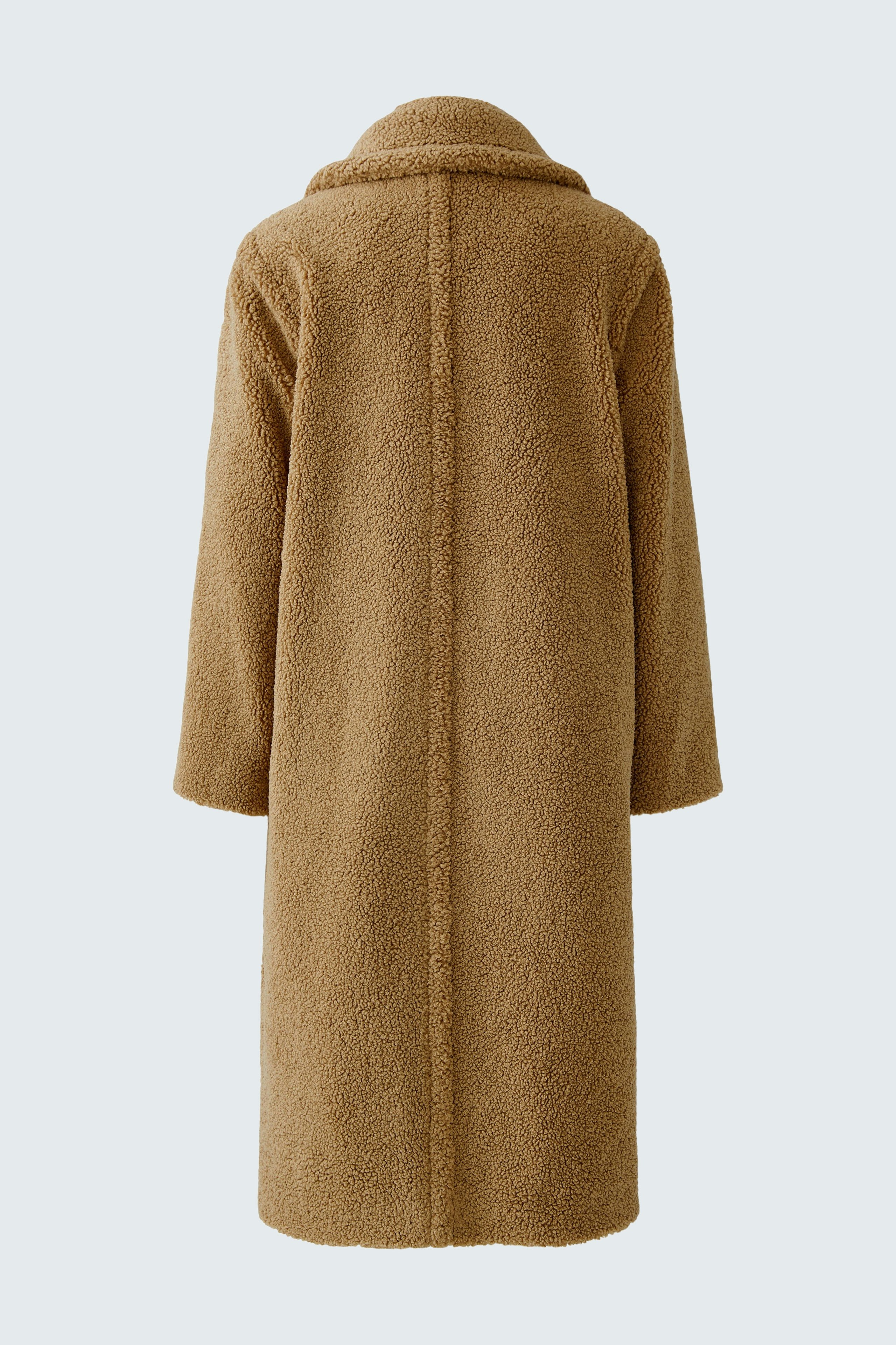 Cozy winter coat: A woman in a soft brown coat with a relaxed fit, perfect for chilly days.