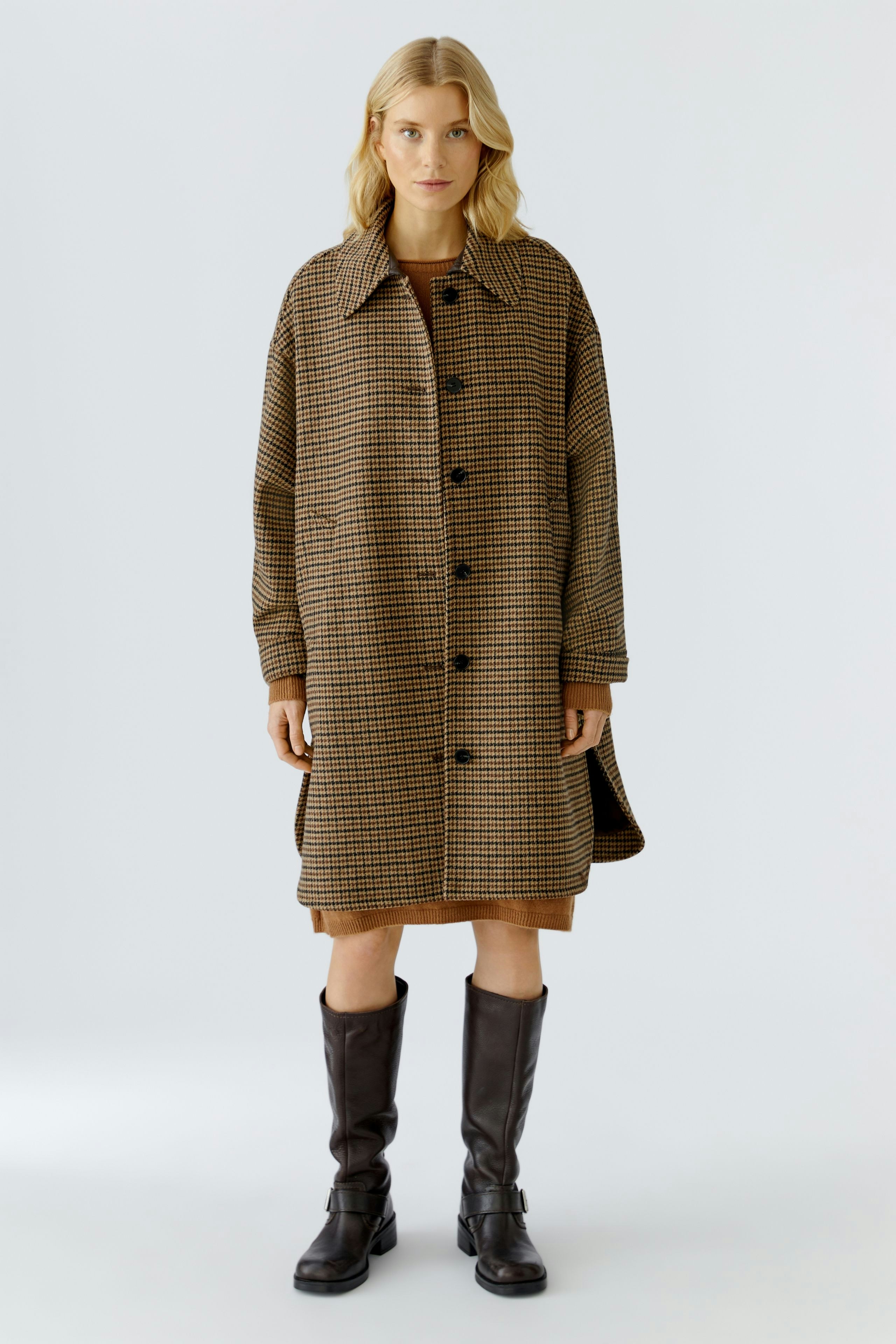 Wool coat: Woman in a brown checkered wool coat, paired with knee-high boots, stands confidently.